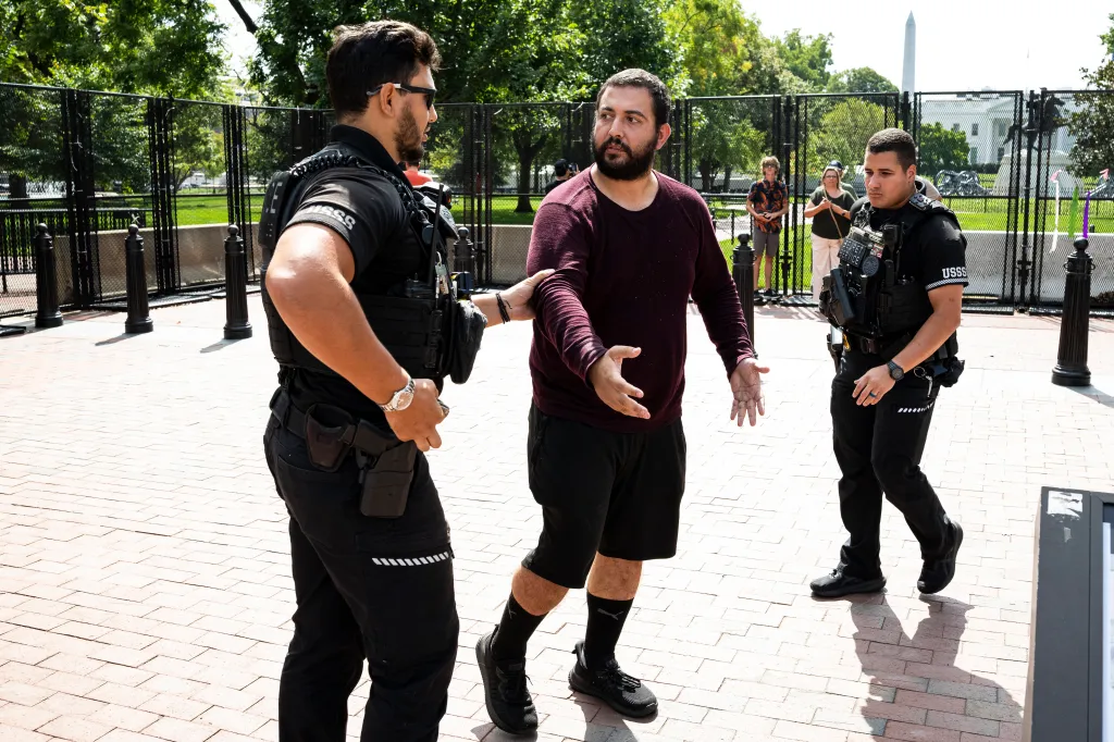 Two Secret Service officers arresting a person near the White House.