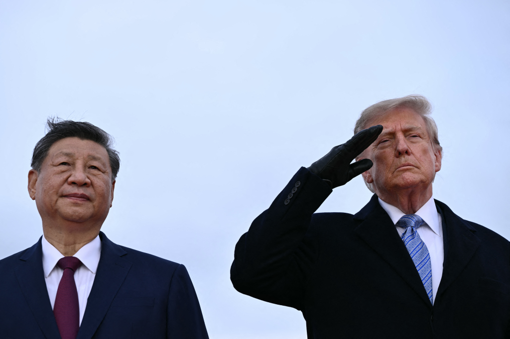 US President Donald Trump (right) salutes next to Chinese President Xi Jinping.