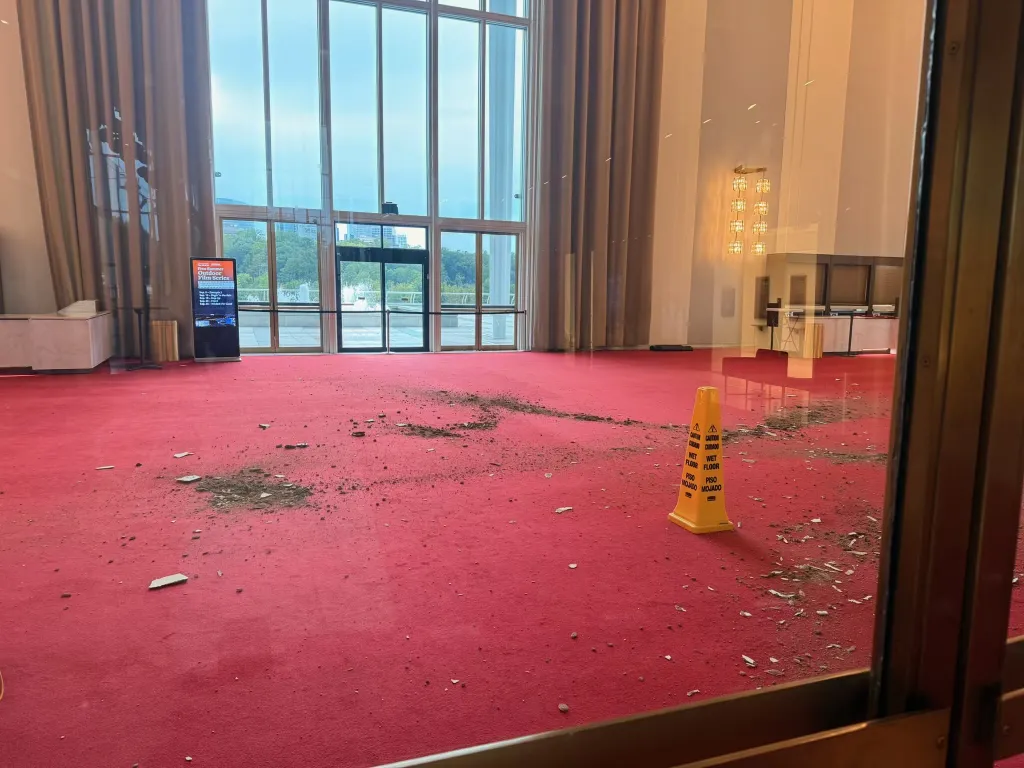The Grand Foyer of the Kennedy Center with debris on the red carpet from a collapsed ceiling section.