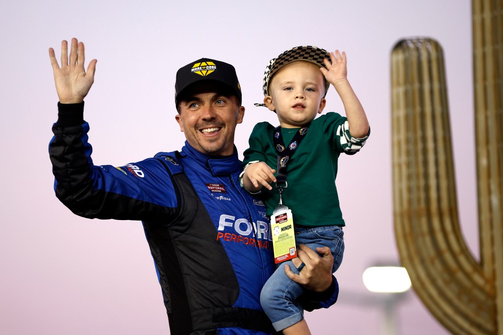 Frankie Muniz, driver of the #27 More Core Diamond Drilling Ford, holding his son at the NASCAR Craftsman Truck Series Championship Race.