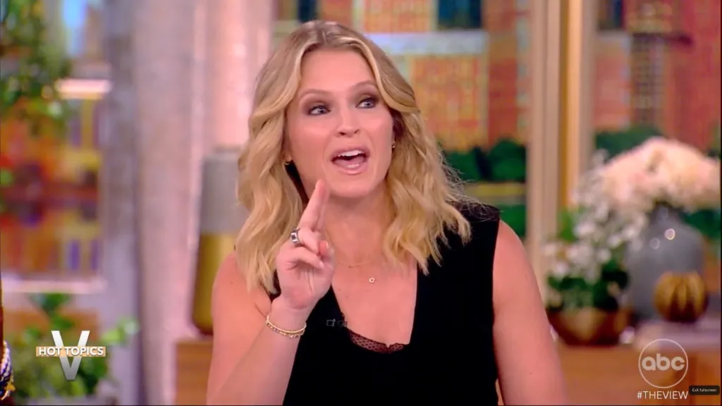 Sara Haines from The View, wearing a black top, pointing her finger while speaking.