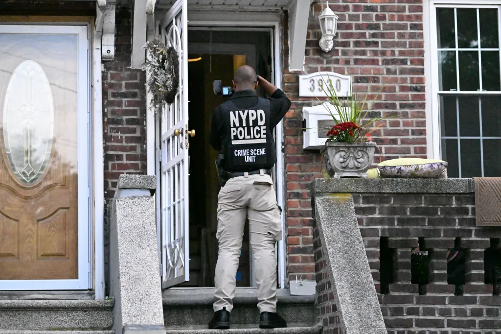 An NYPD crime scene unit investigator photographs the scene at 3930 Bailey Avenue in the Bronx.