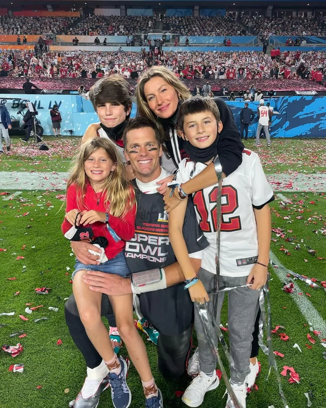 Tom Brady celebrating his Super Bowl victory with his family on the field.