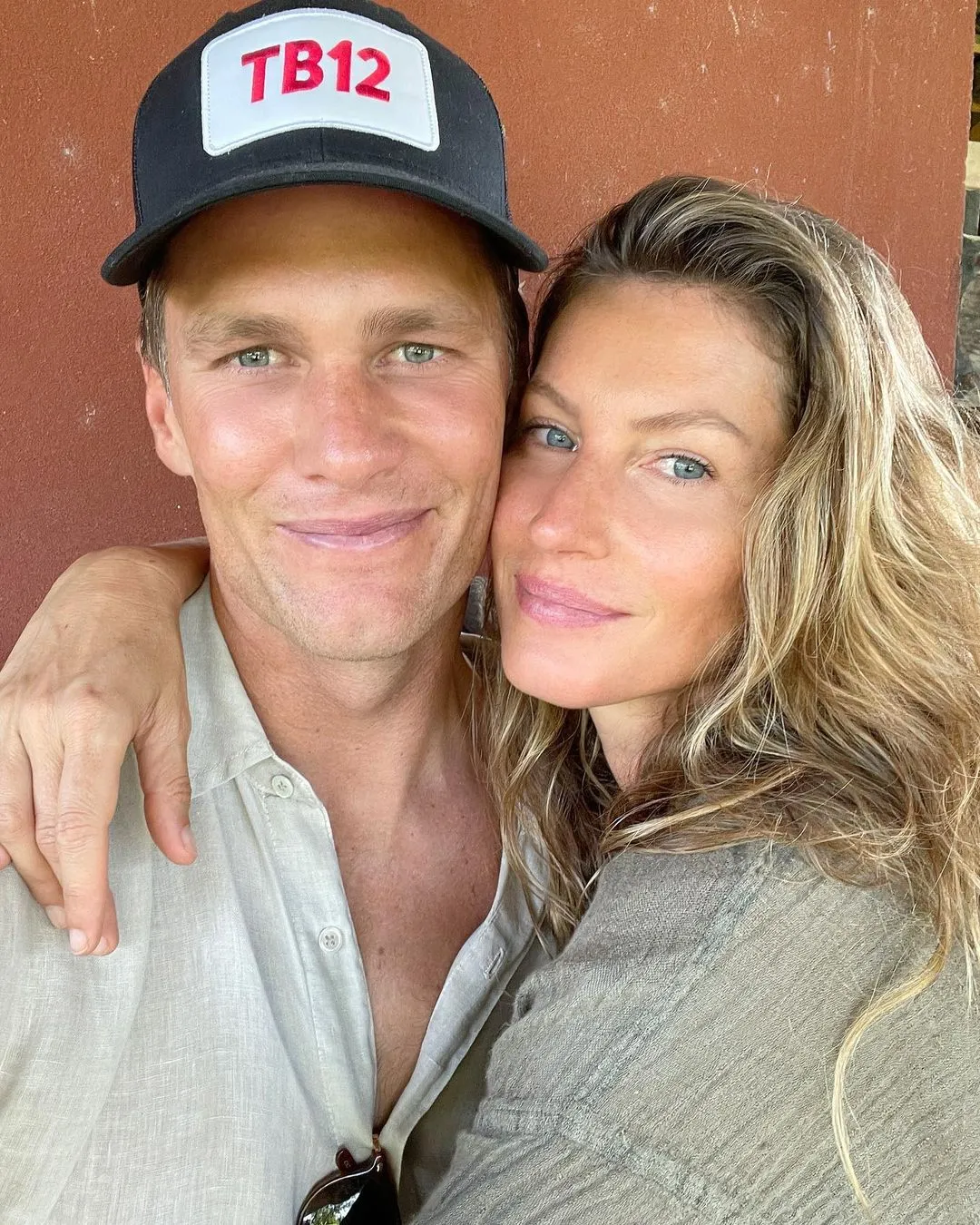 Tom Brady in a TB12 hat with his arm around Gisele Bündchen.