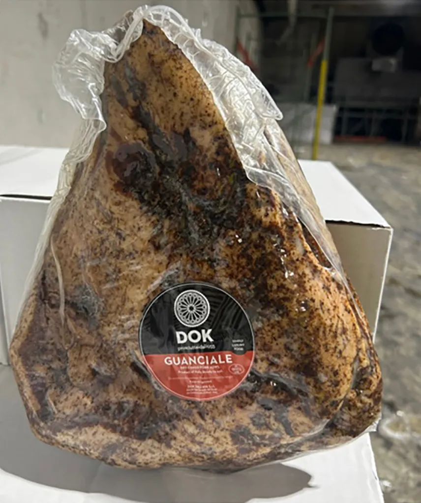 A vacuum-sealed package of Guanciale, an imported, pre-packaged pork product.