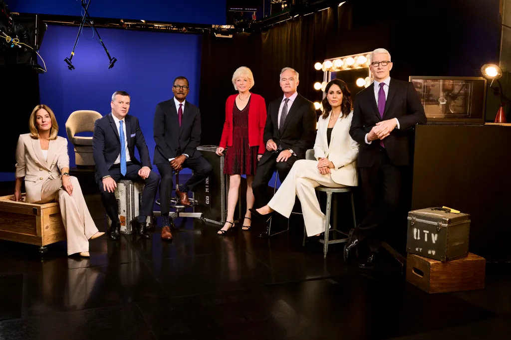 60 Minutes correspondents, Sharyn Alfonsi, L. Jon Wertheim, Bill Whitaker, Lesley Stahl, Scott Pelley, Cecilia Vega, and Anderson Cooper, pose in a studio.