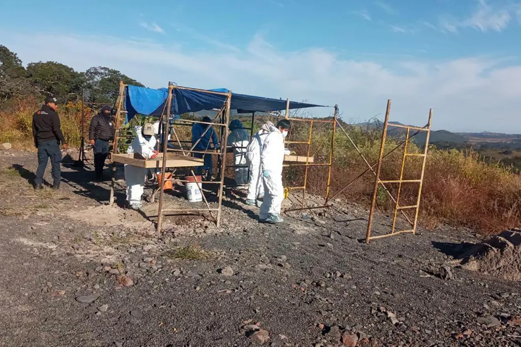 Investigators in hazmat suits at a clandestine burial site in western Mexico.