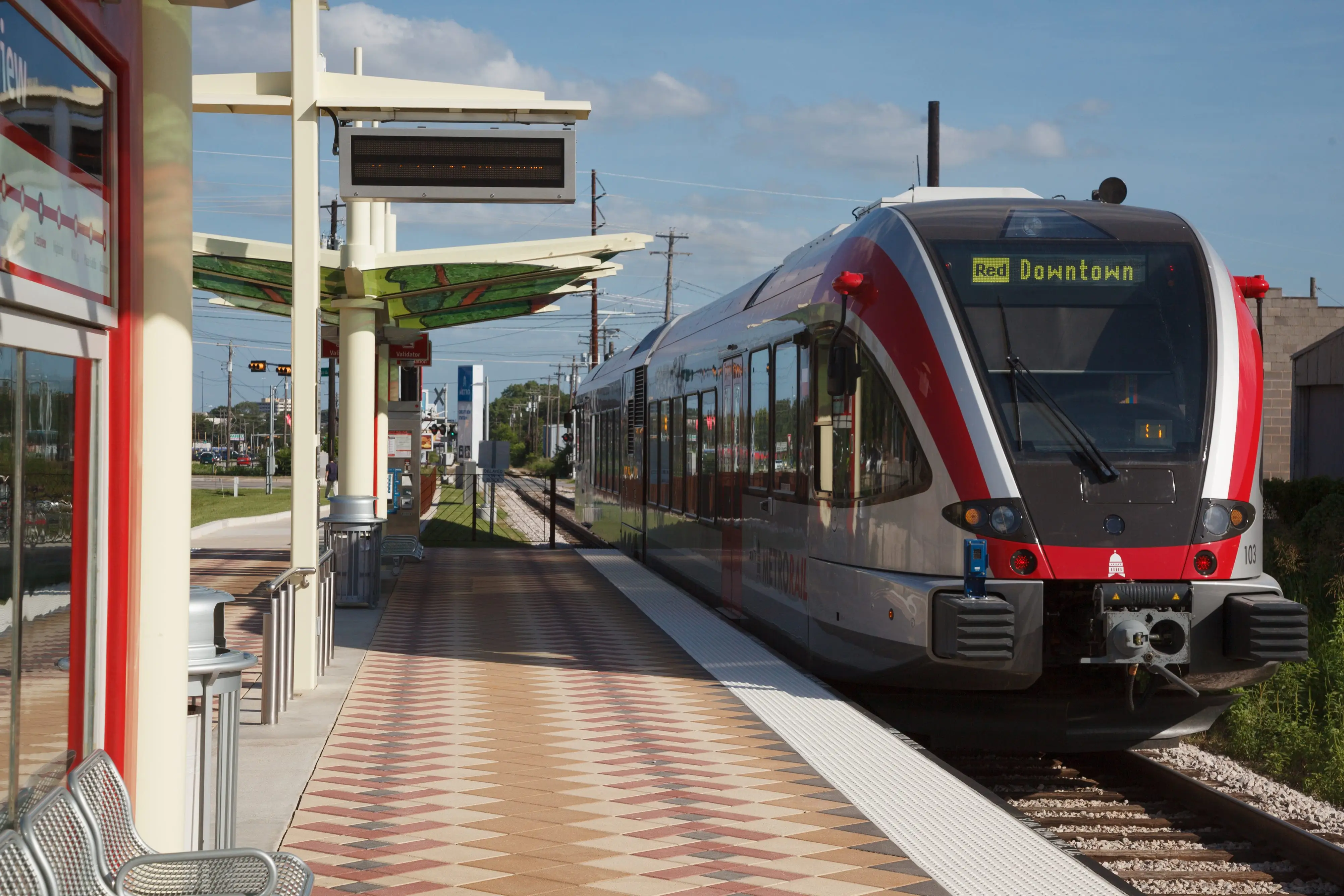 Austin MetroRail train stopped at the light rail station in Austin, Texas, with blue skies in the background