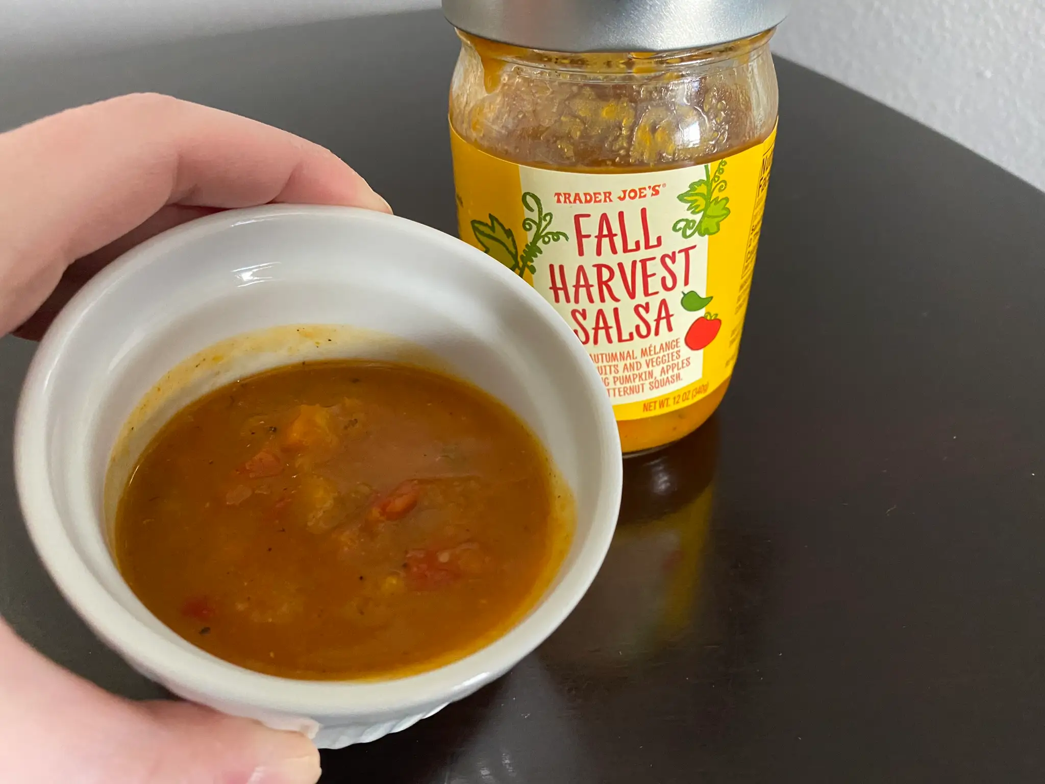 Liquidy brownish salsa in white ramekin