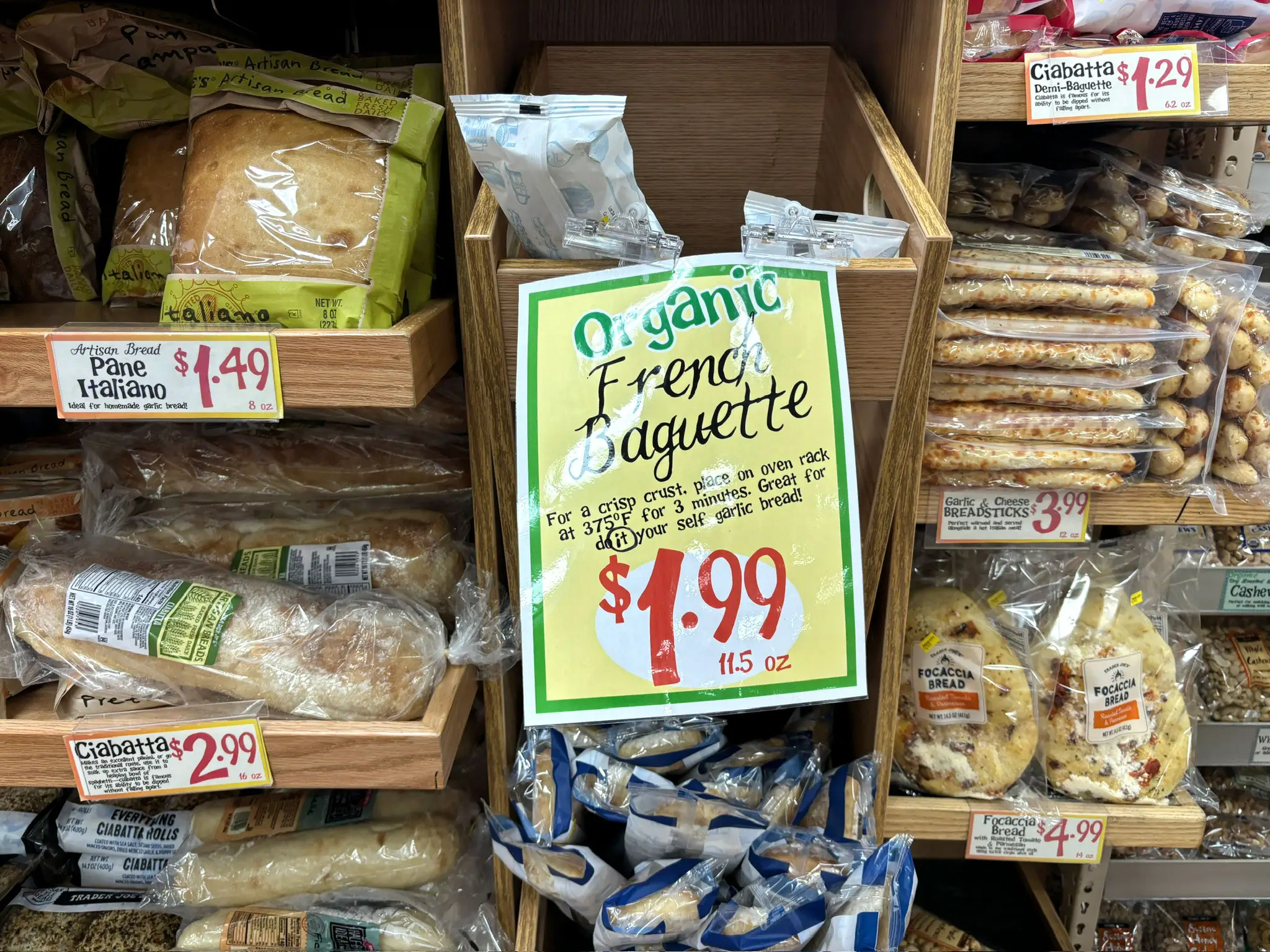 Different kinds of bread on display at Trader Joe's. The largest sign in the middle reads,