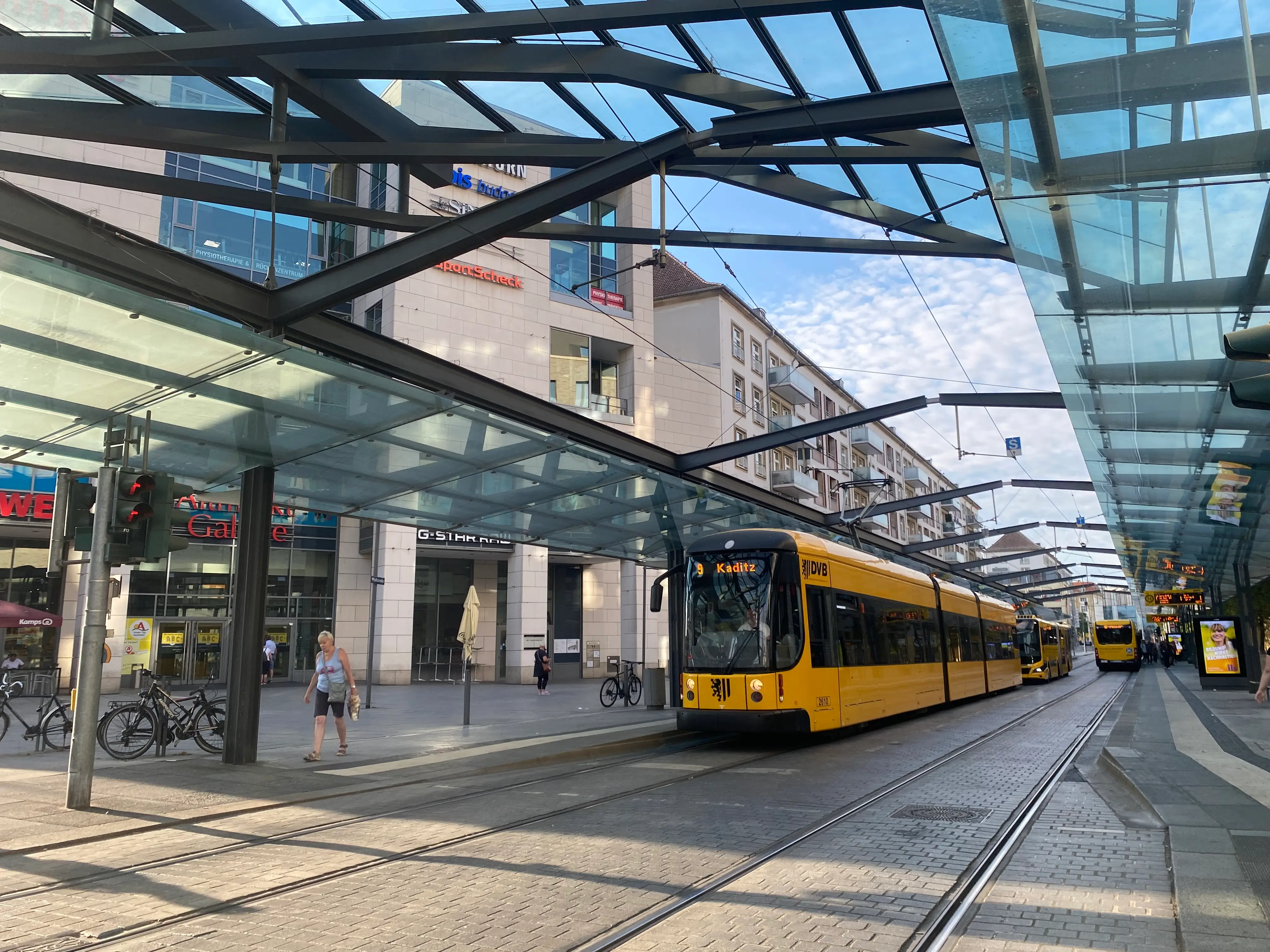 A yellow tram in Germany on a track at the station.