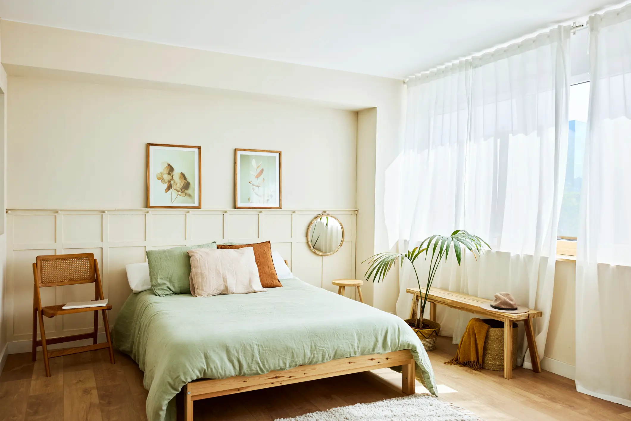 green bedding with pillows in a neutral boho chic bedroom