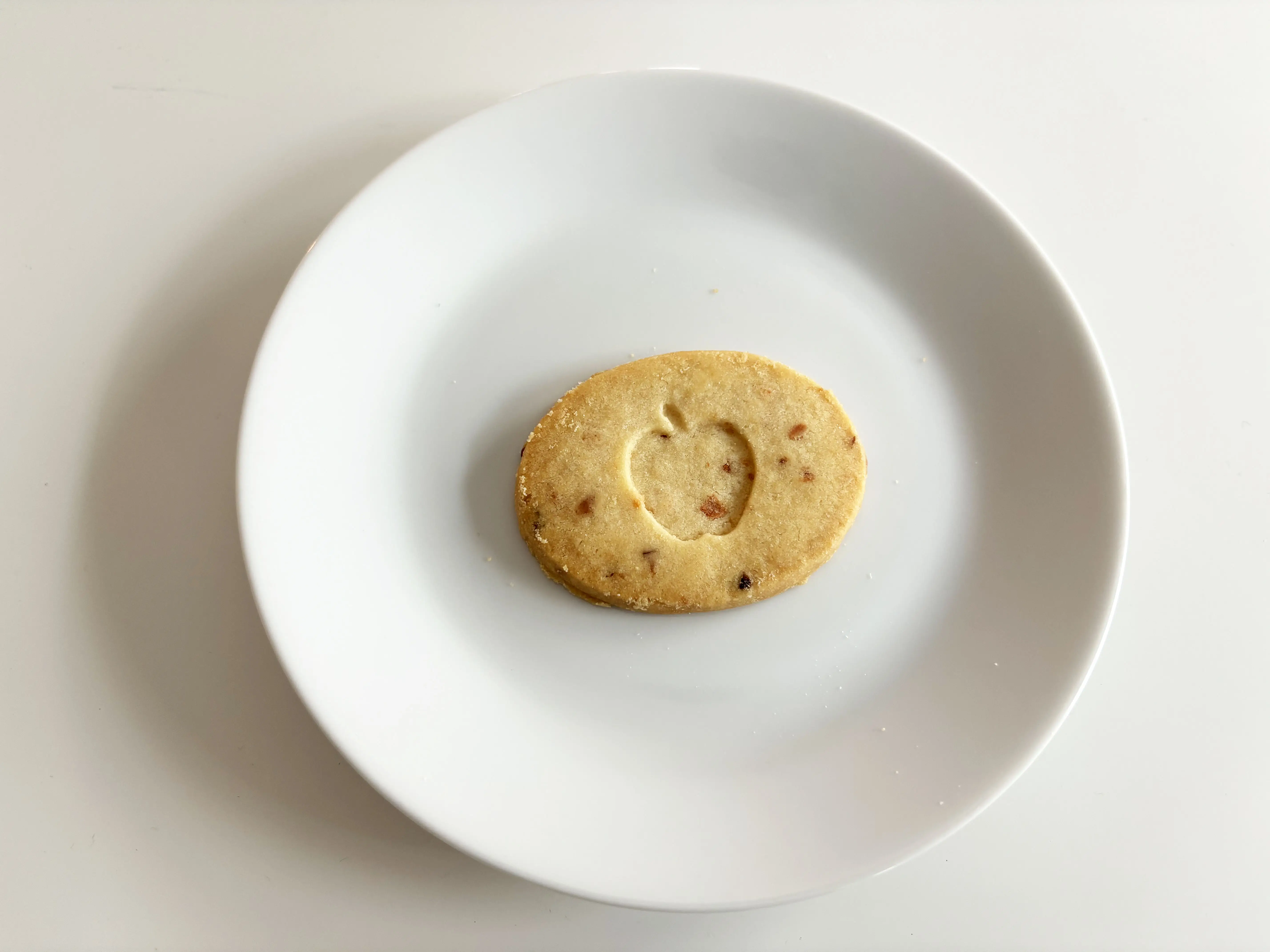 A shortbread cookie with an apple shape carved into the center.
