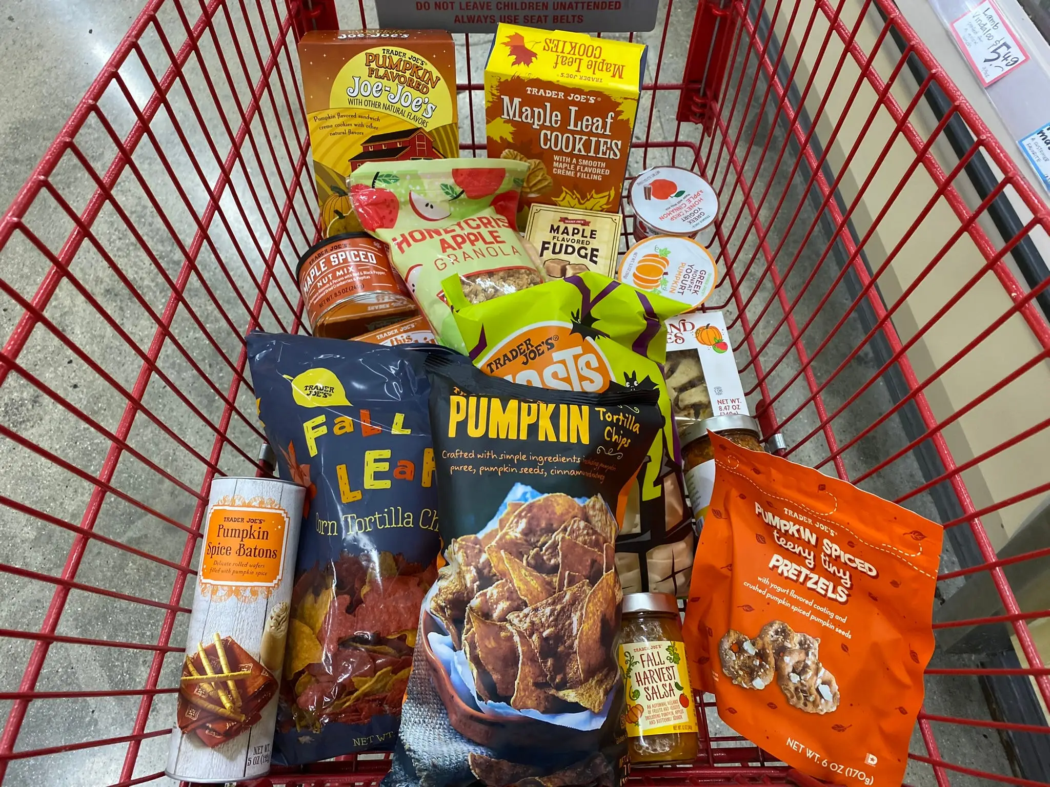 Trader Joe's shopping cart filled with fall chips, snacks, and cookies