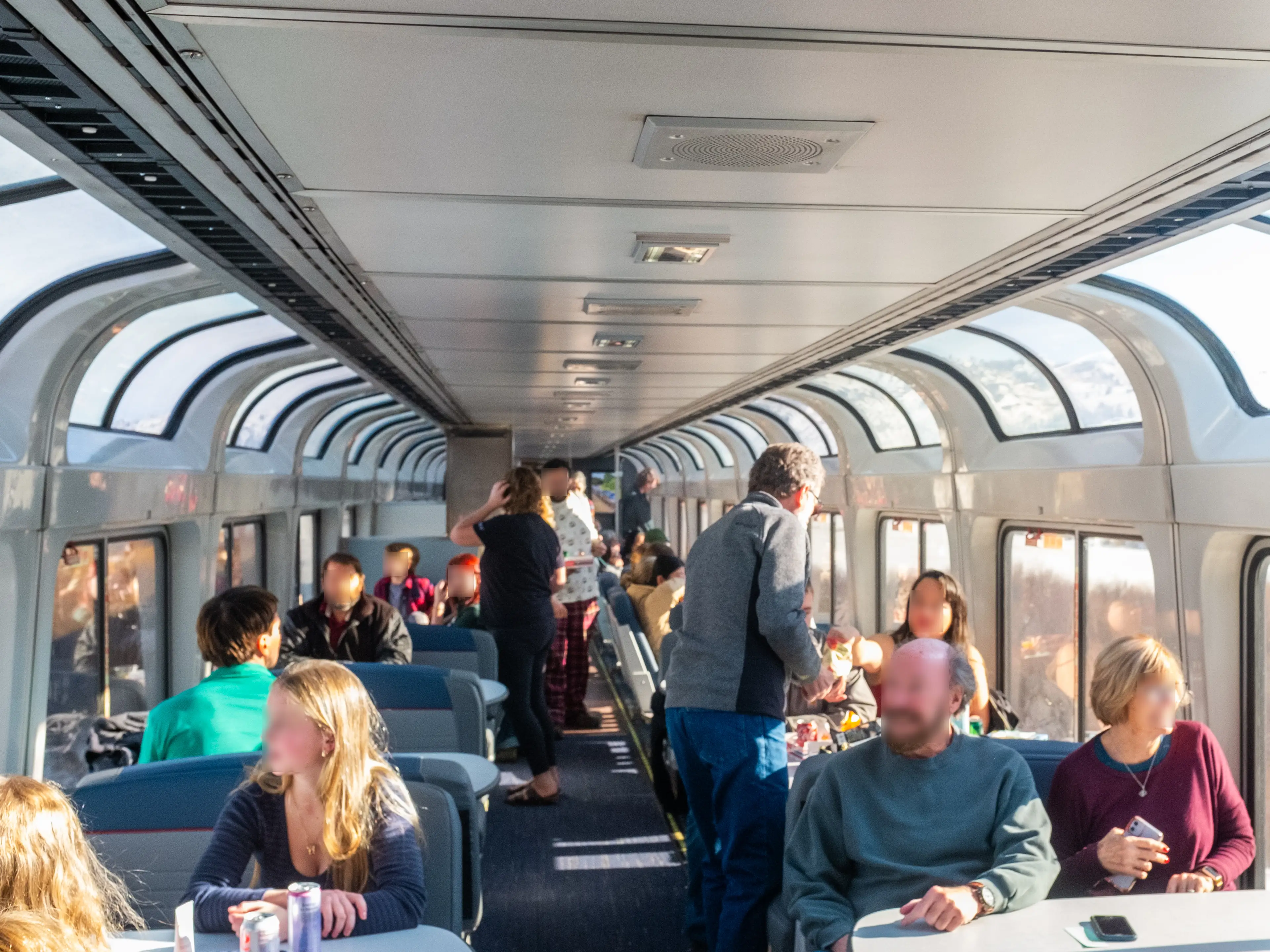 Inside a full train car with two rows of windows on either side