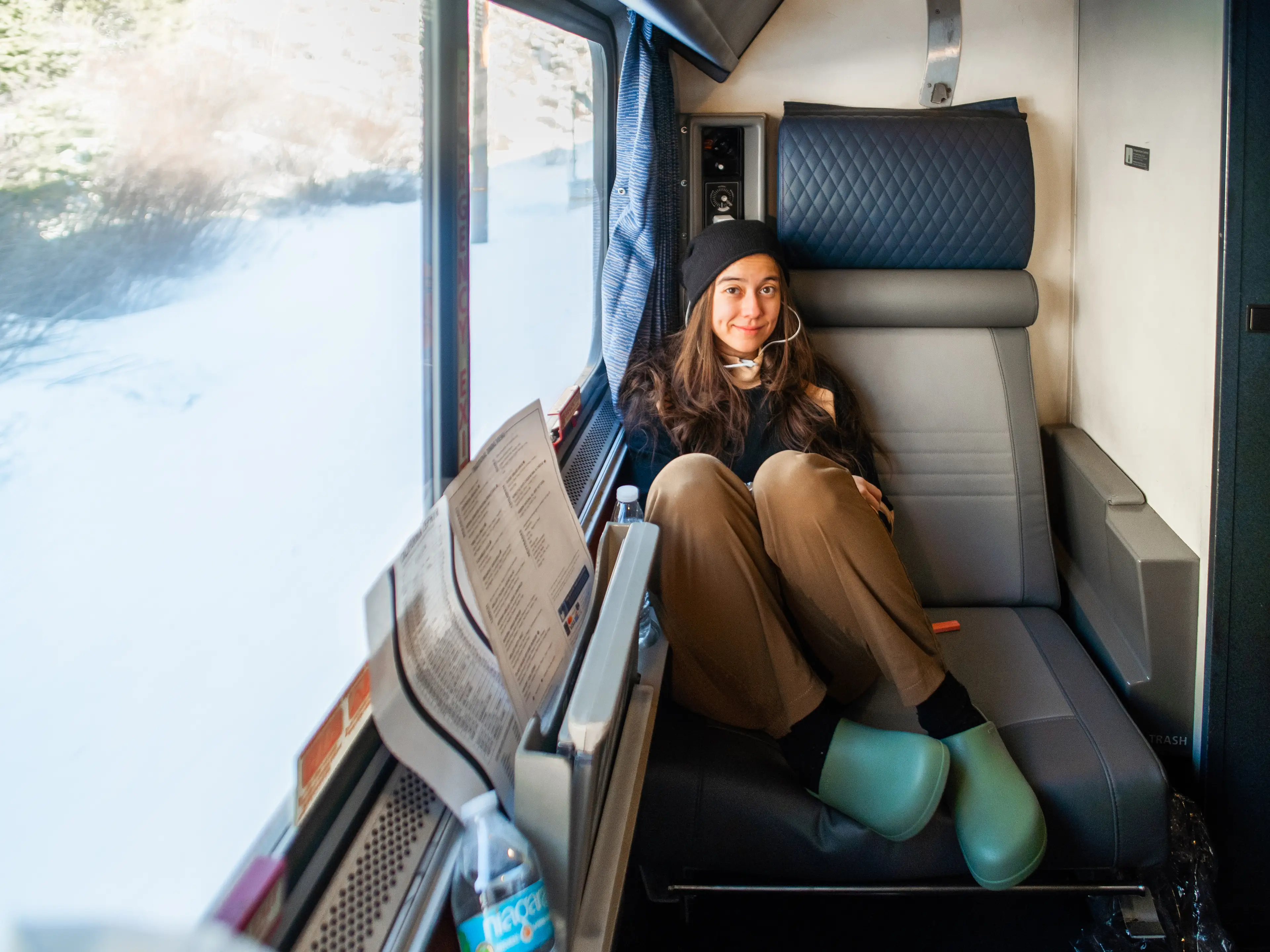 The author sits in a train cabin with a window on the left