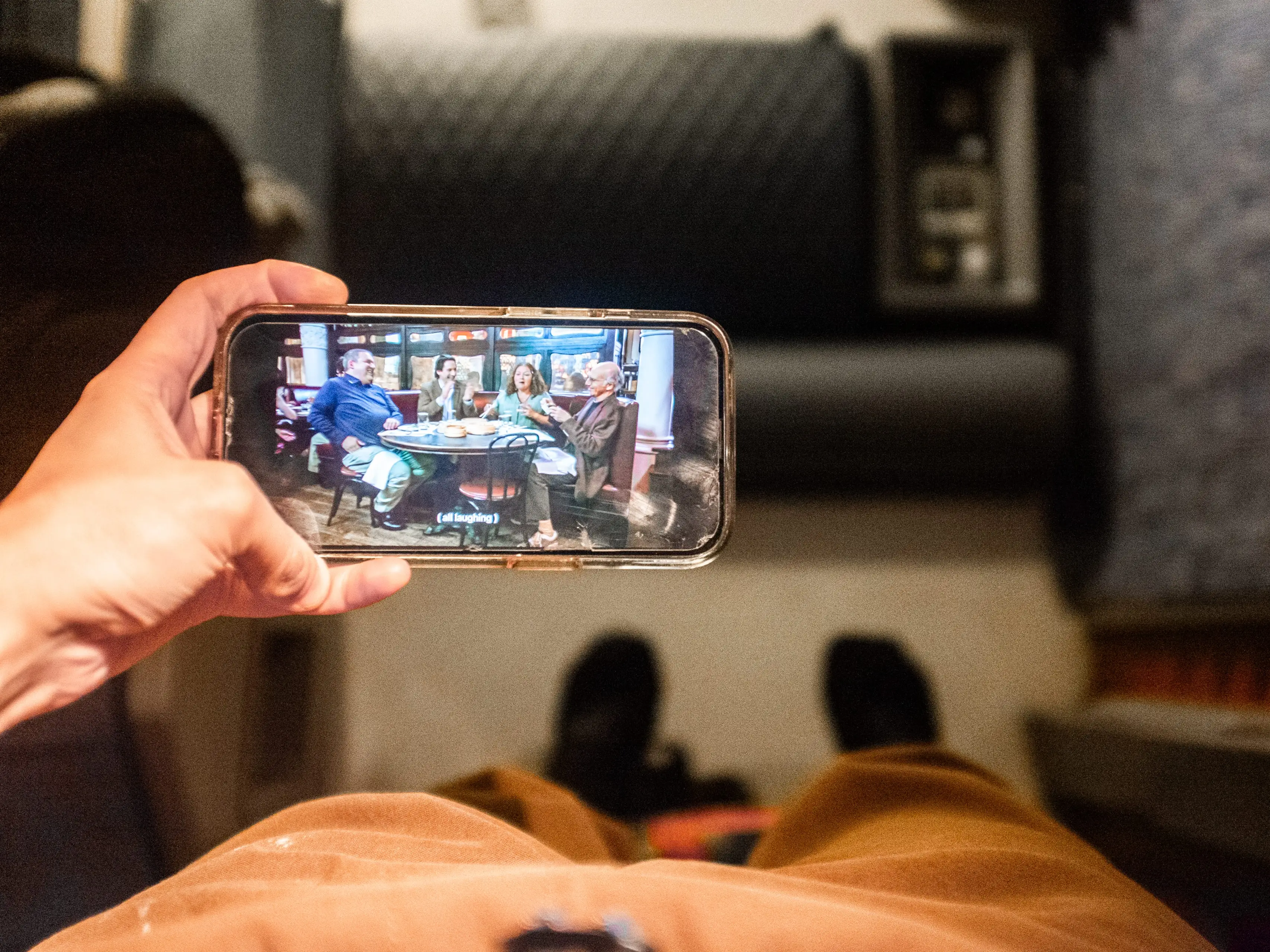 POV shot laying in a train bed holding a phone with a TV show playing
