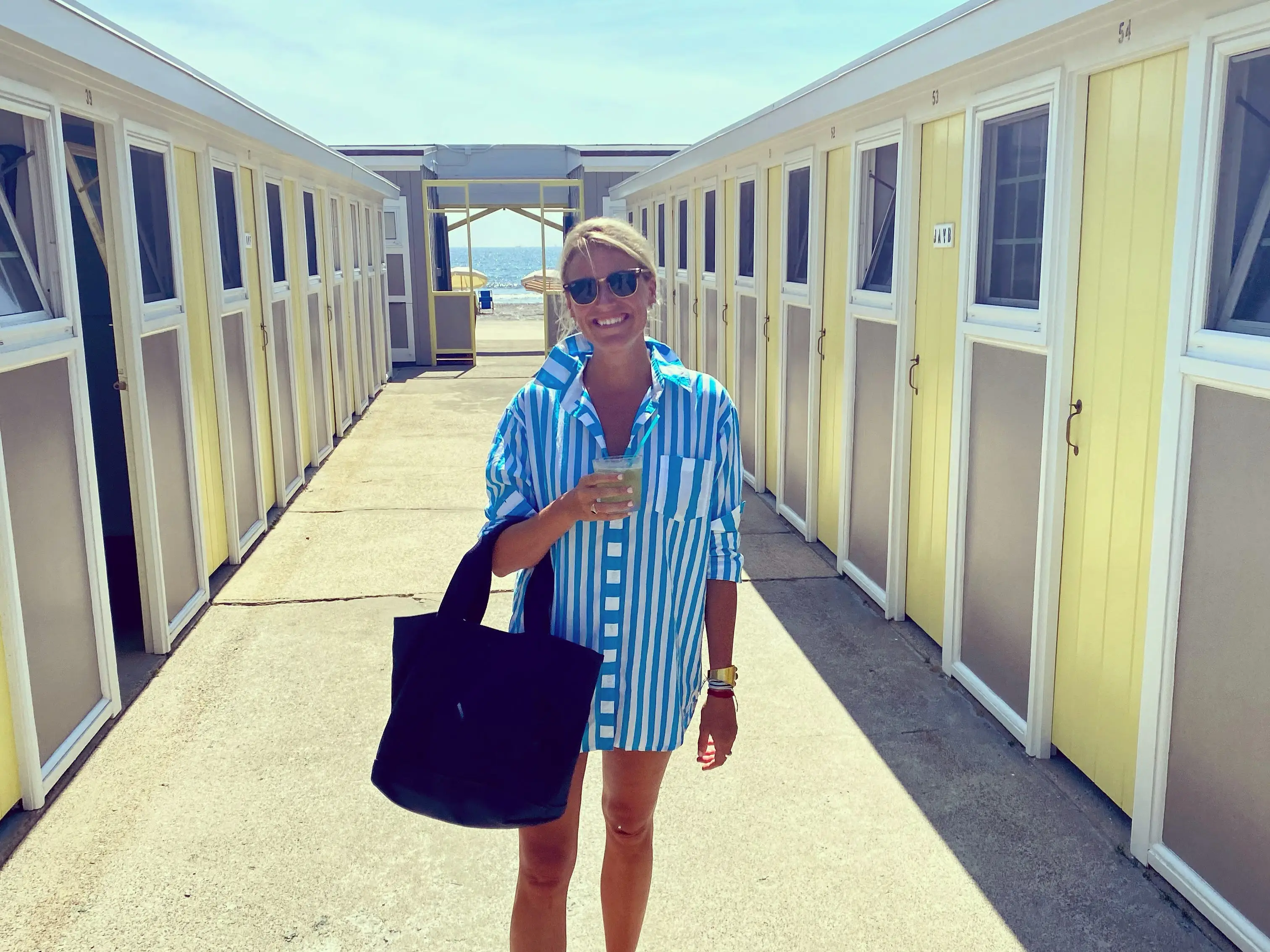 Author Katherine Parker-Magyar heading to beach in Rhode Island standing between two low buildings