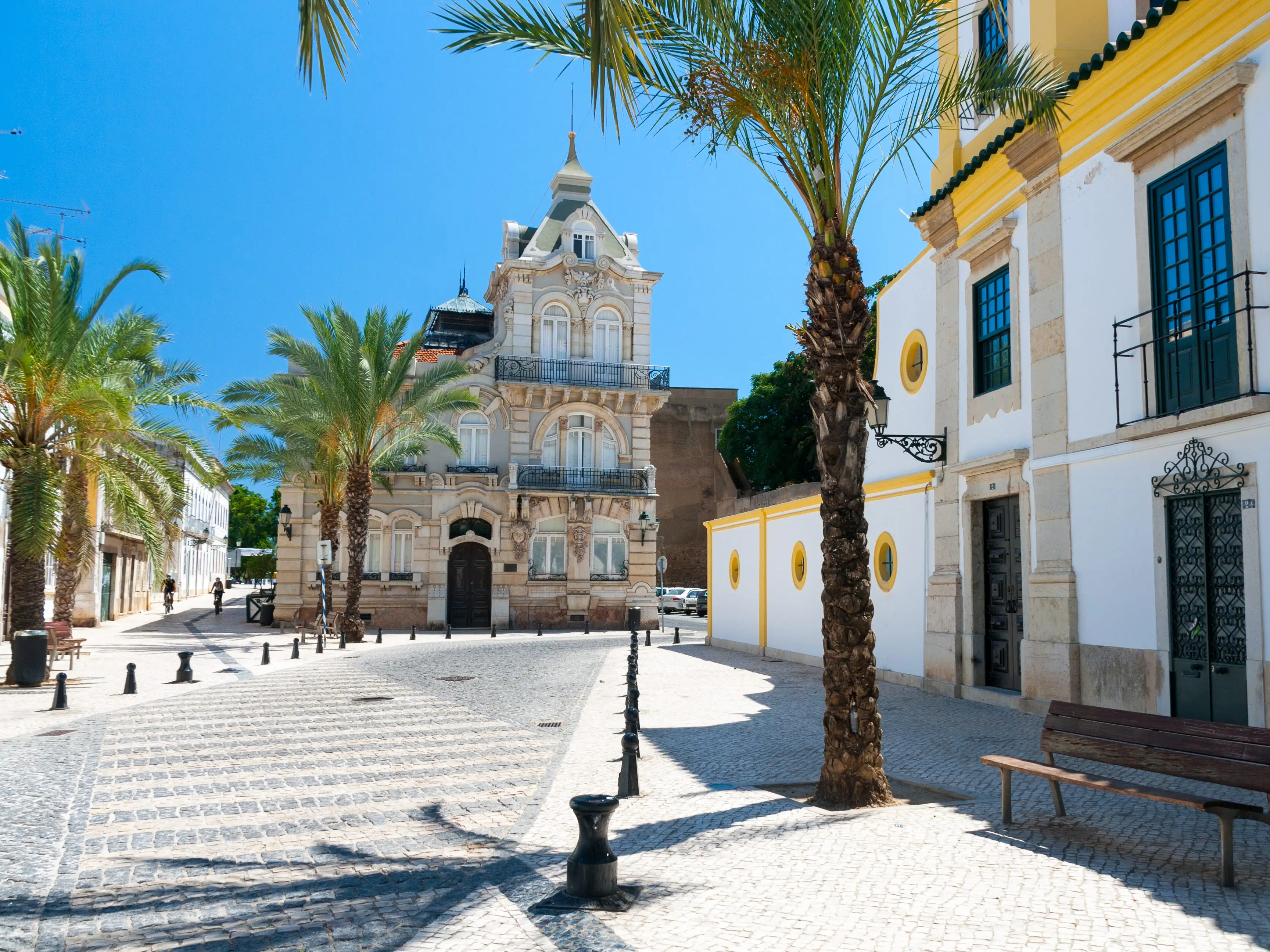 Old buildings in a courtyard with palm trees.
