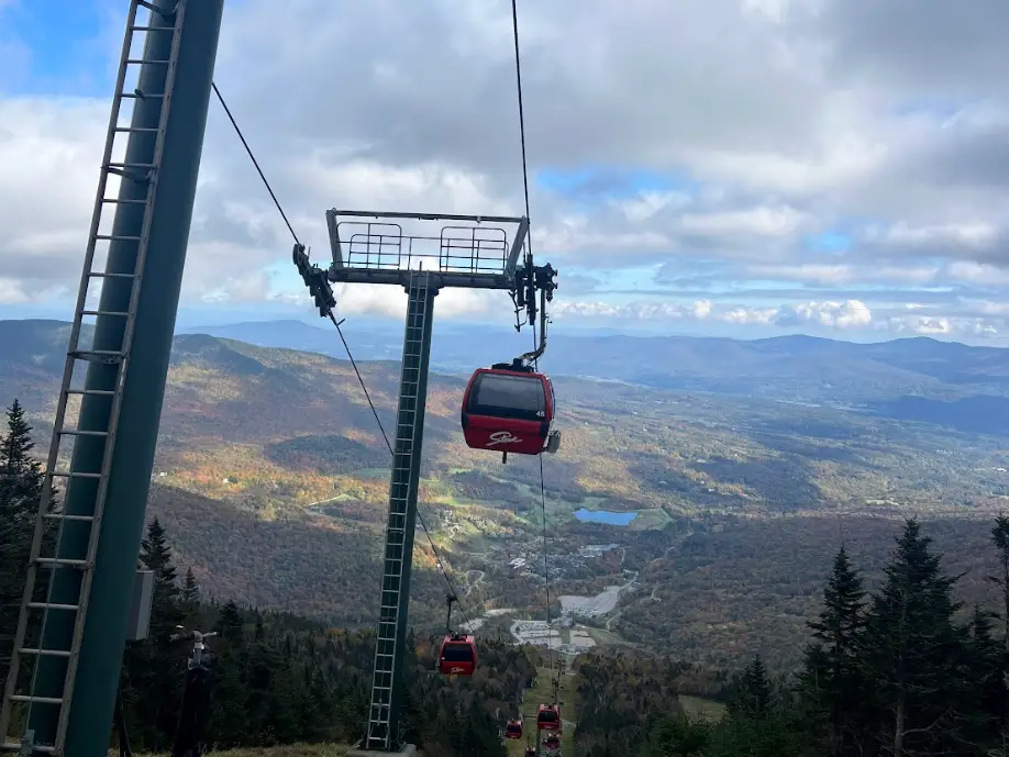 Shot of a red gondola overlooking a mountain.