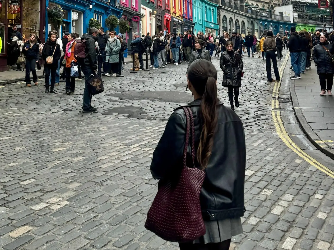 Amanda looking away from the camera at the colorful buildings on Victoria Stret.