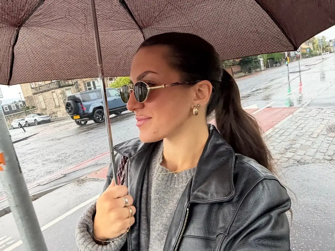 Amanda holding an umbrella above her head.