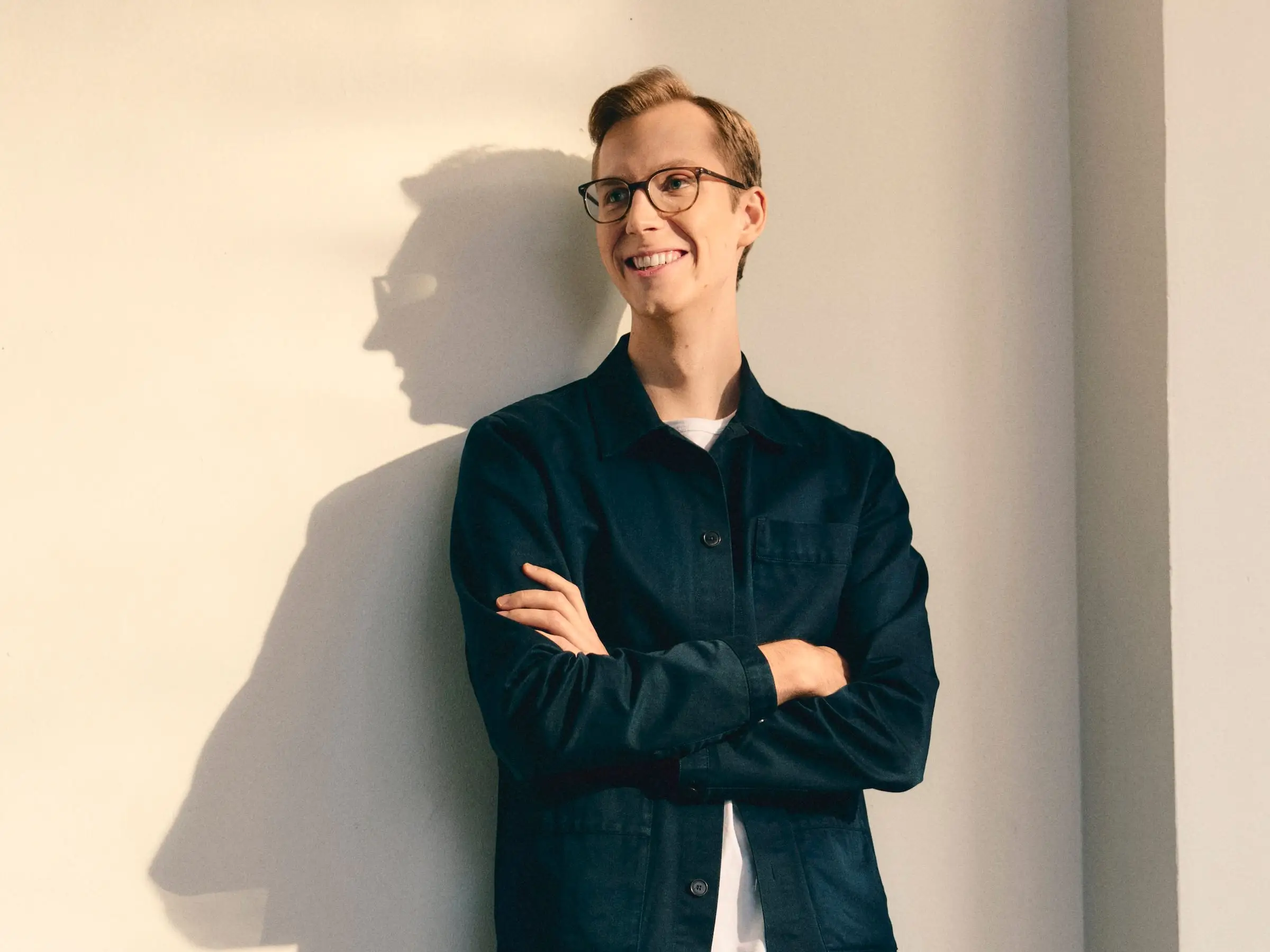 Legora's CEO leans against a wall with arms folded over his chest.