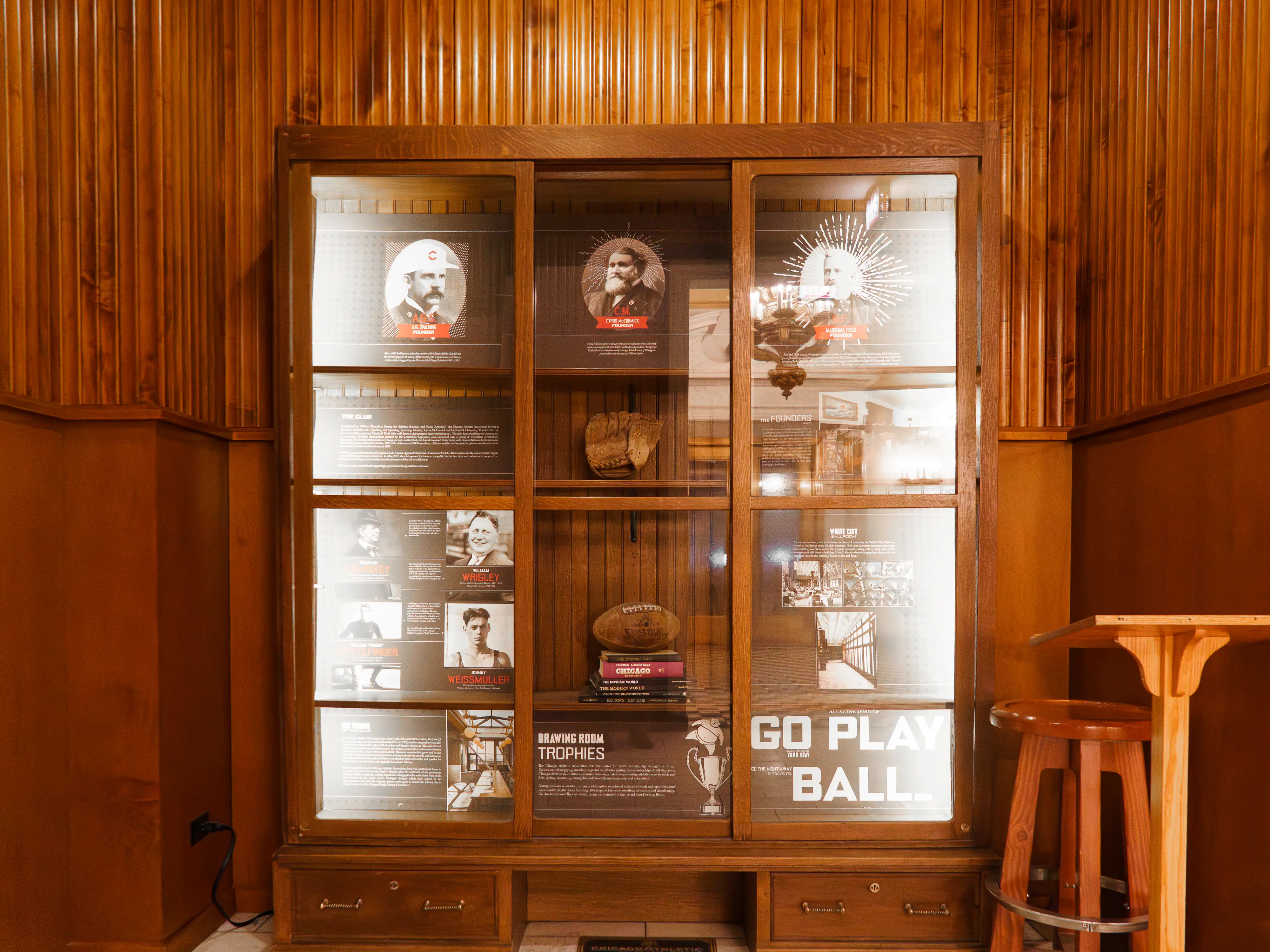 A wooden glass case displays historical facts and relics from the Chicago Athletic Association