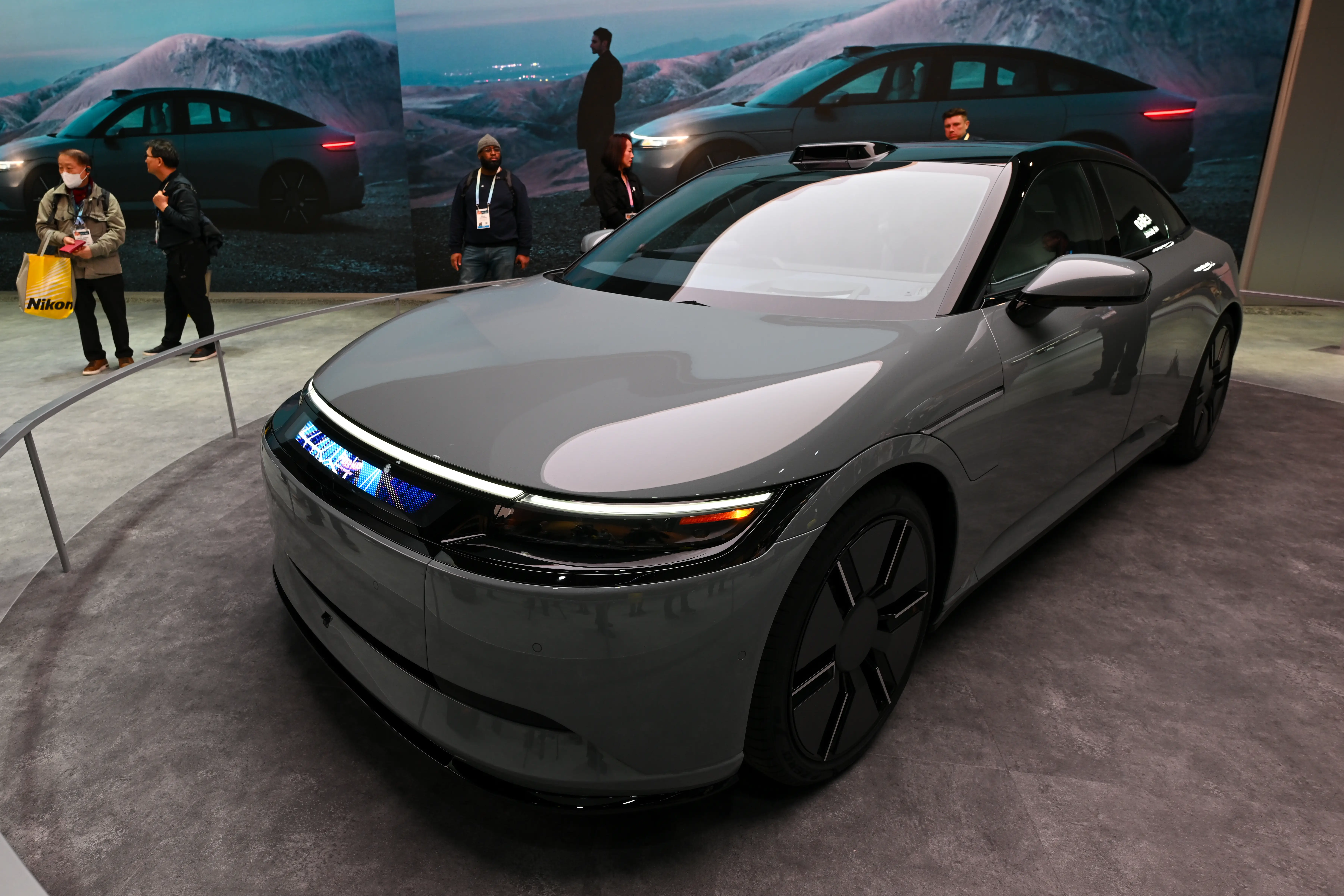 A gray Sony Honda Mobility Afeela sedan on showcase during an auto show.