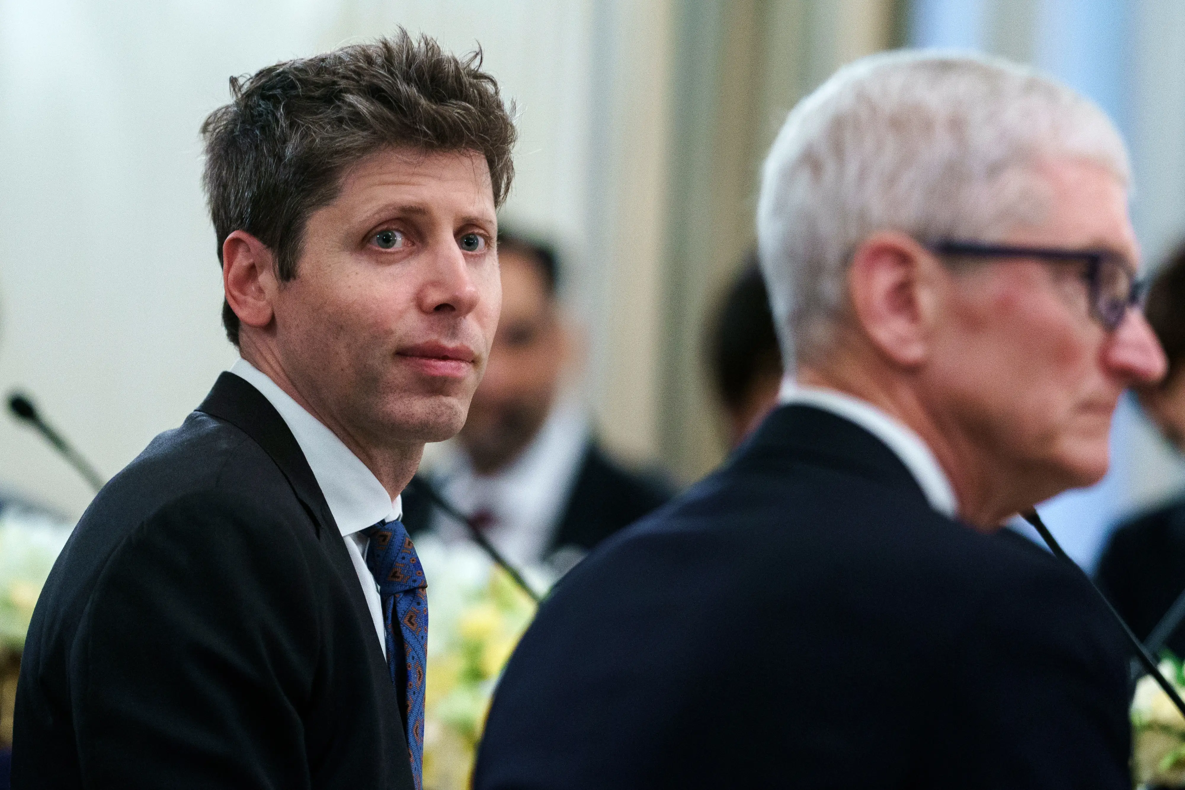 OpenAI CEO Sam Altman looks past Apple CEO Tim Cook.