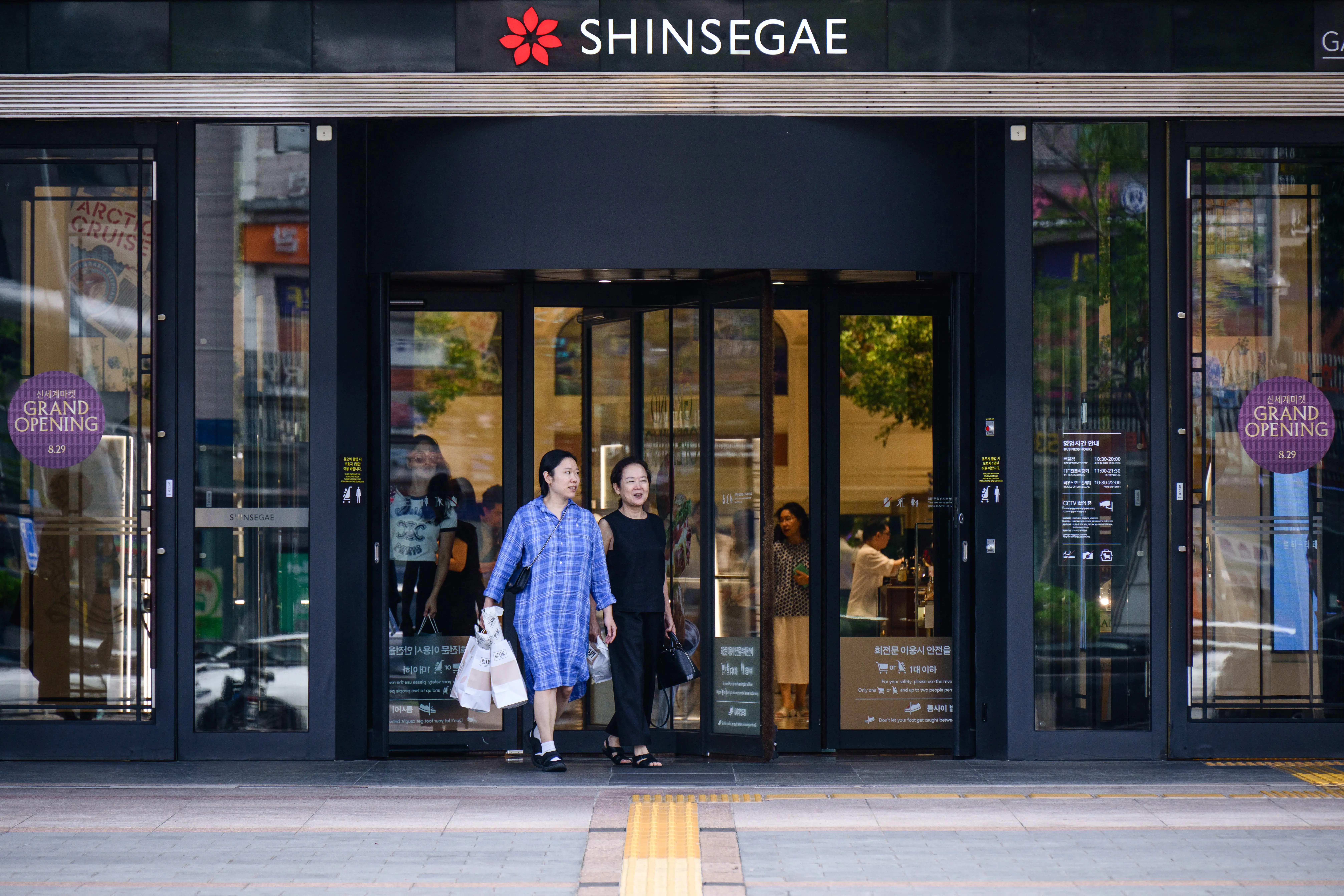 Customers walk out from a shopping mall of South Korean conglomerate and retail giant Shinsegae in Seoul.