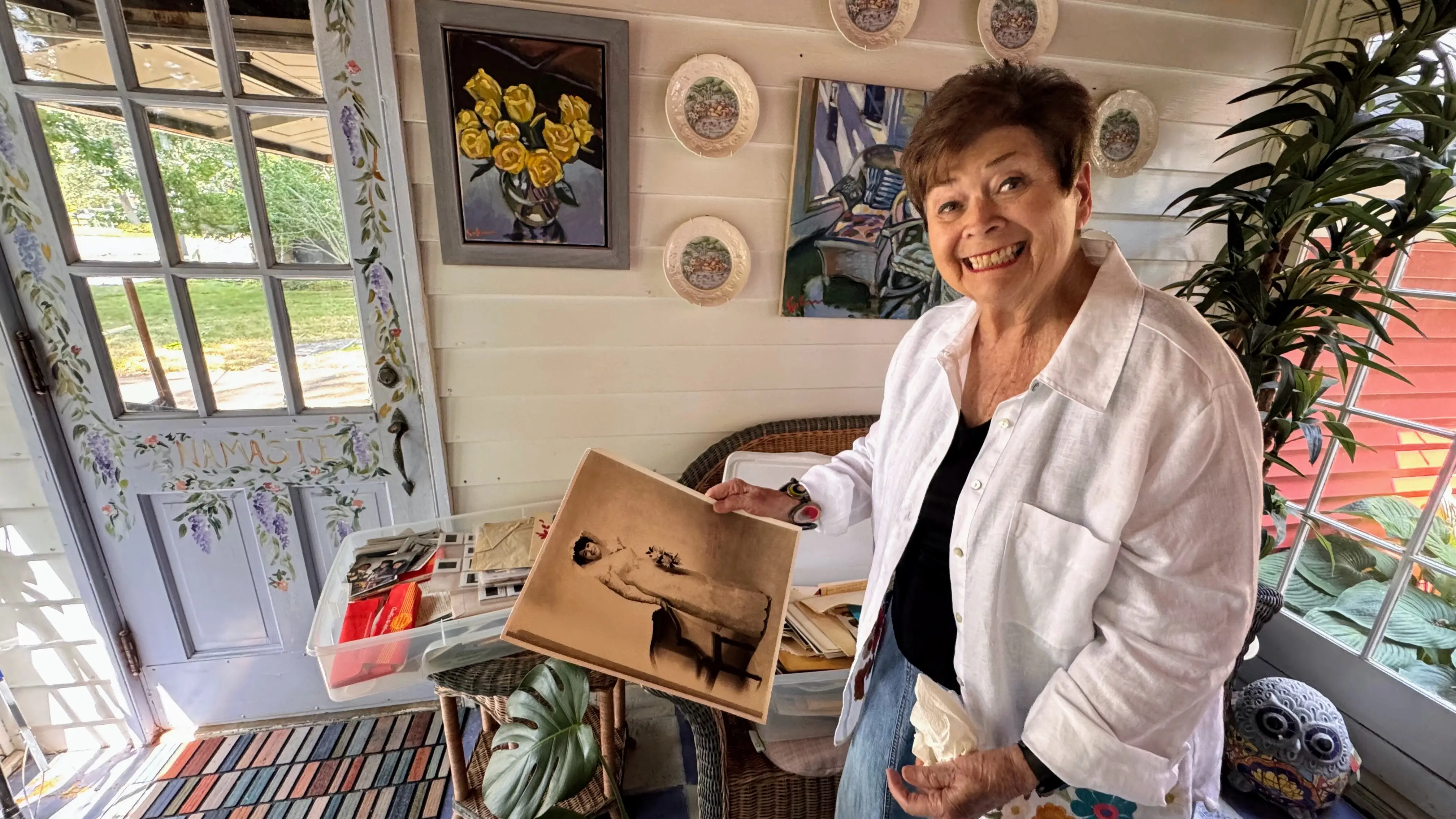 Woman smiling, holding old photo