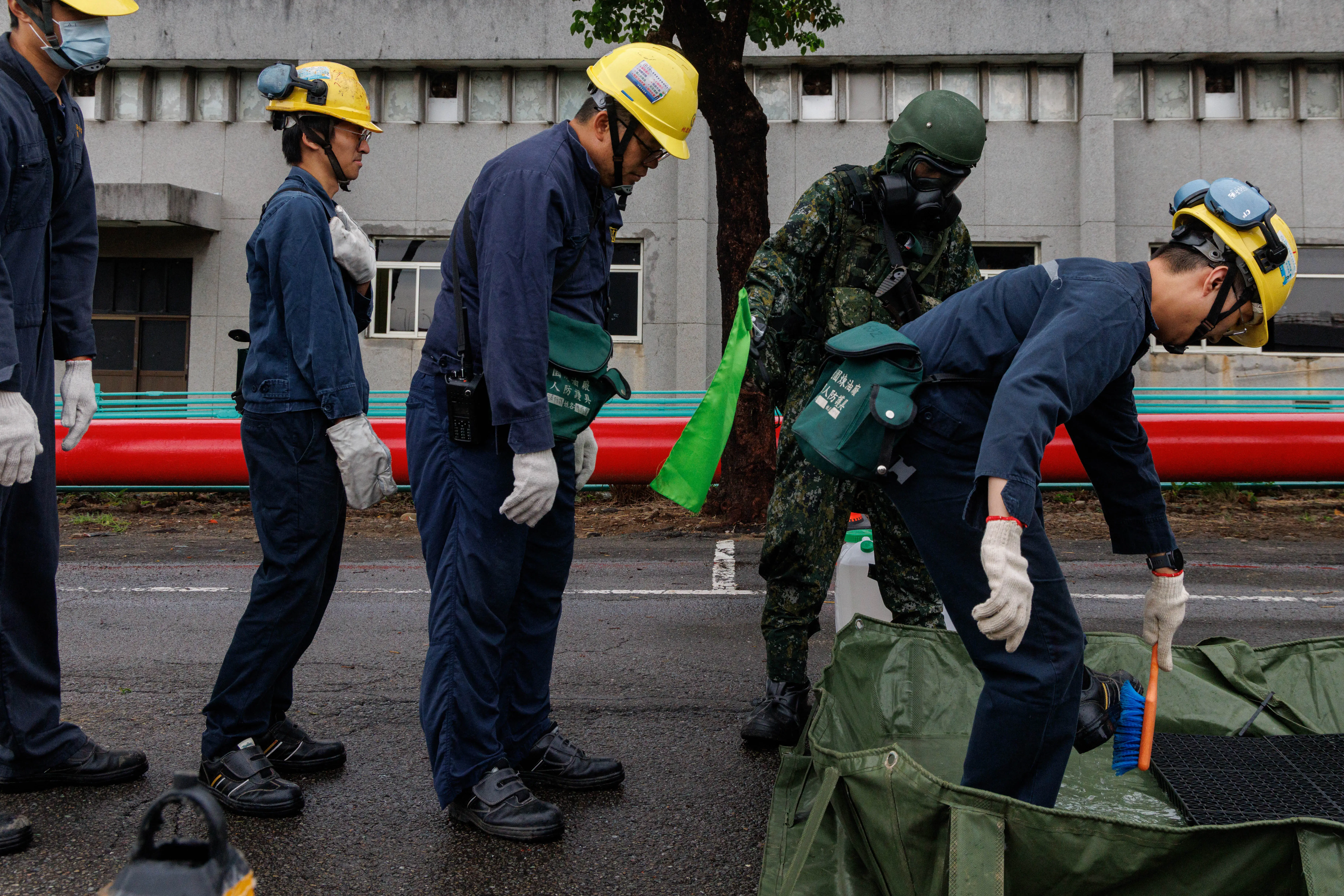 Taiwanese workers line up before a decontamination station.