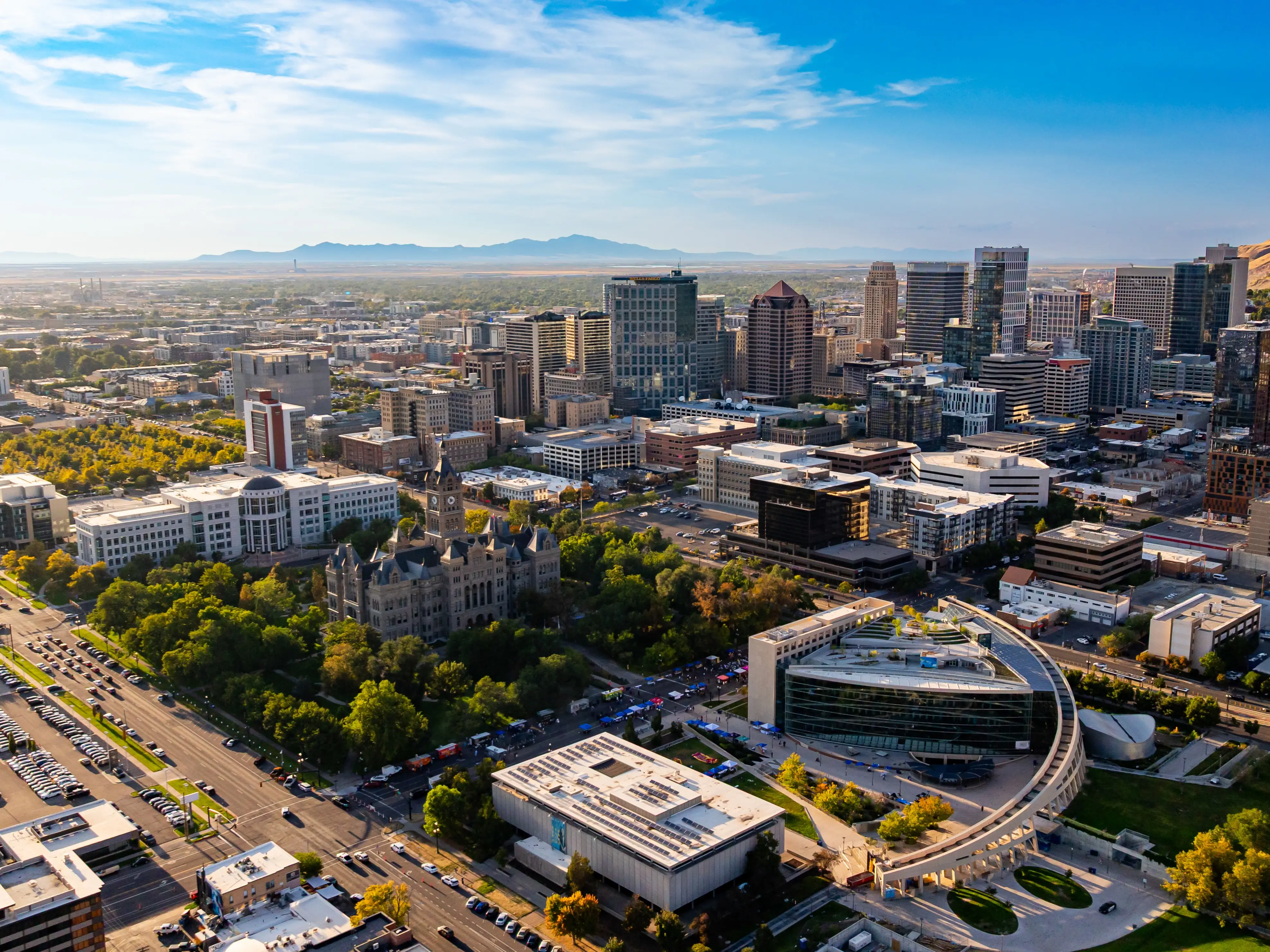 Beautiful Salt Lake City, Utah, USA at sunset time. Downtown and green outskirts of the city with rocks at backdrop. Aerial view.