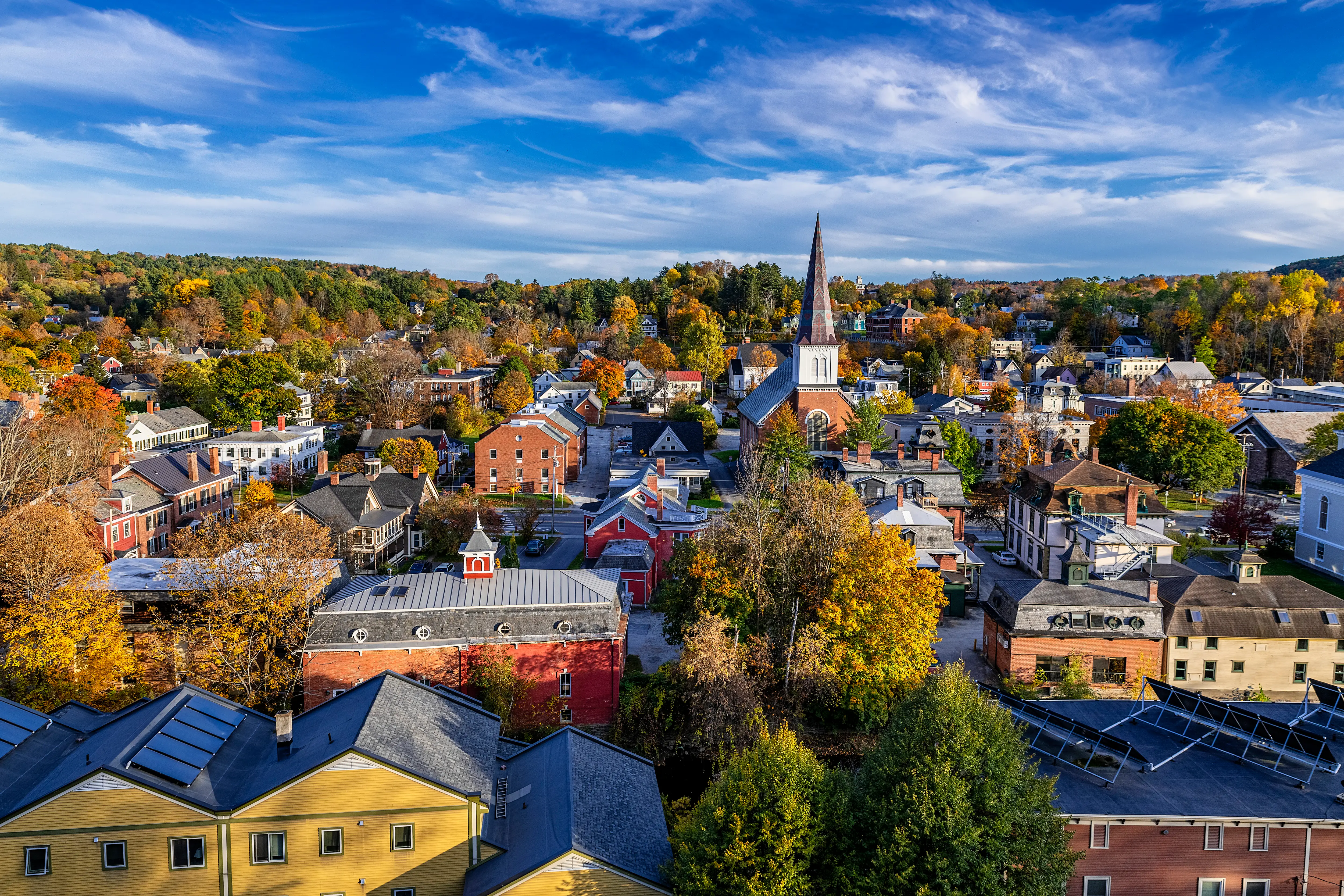 The downtown area of a small town covered in fall foliage.