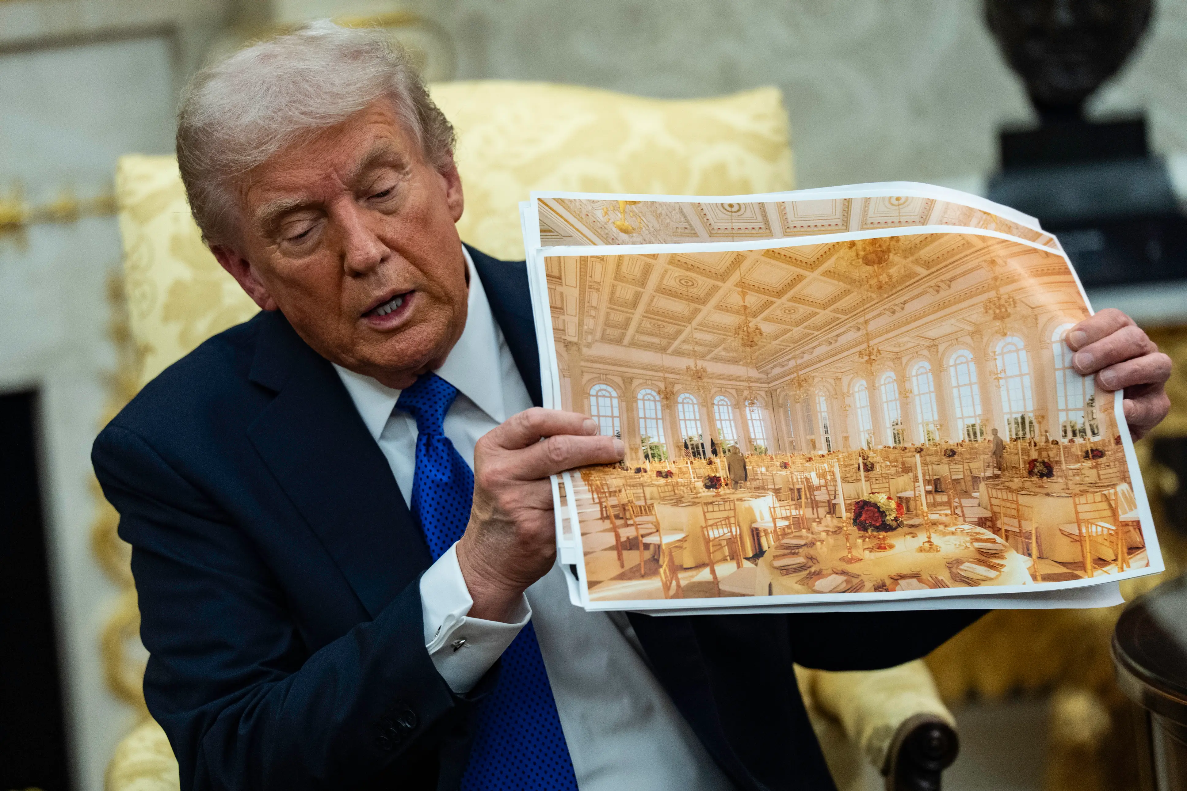 Donald Trump holds a photo of a rendering of the new ballroom.