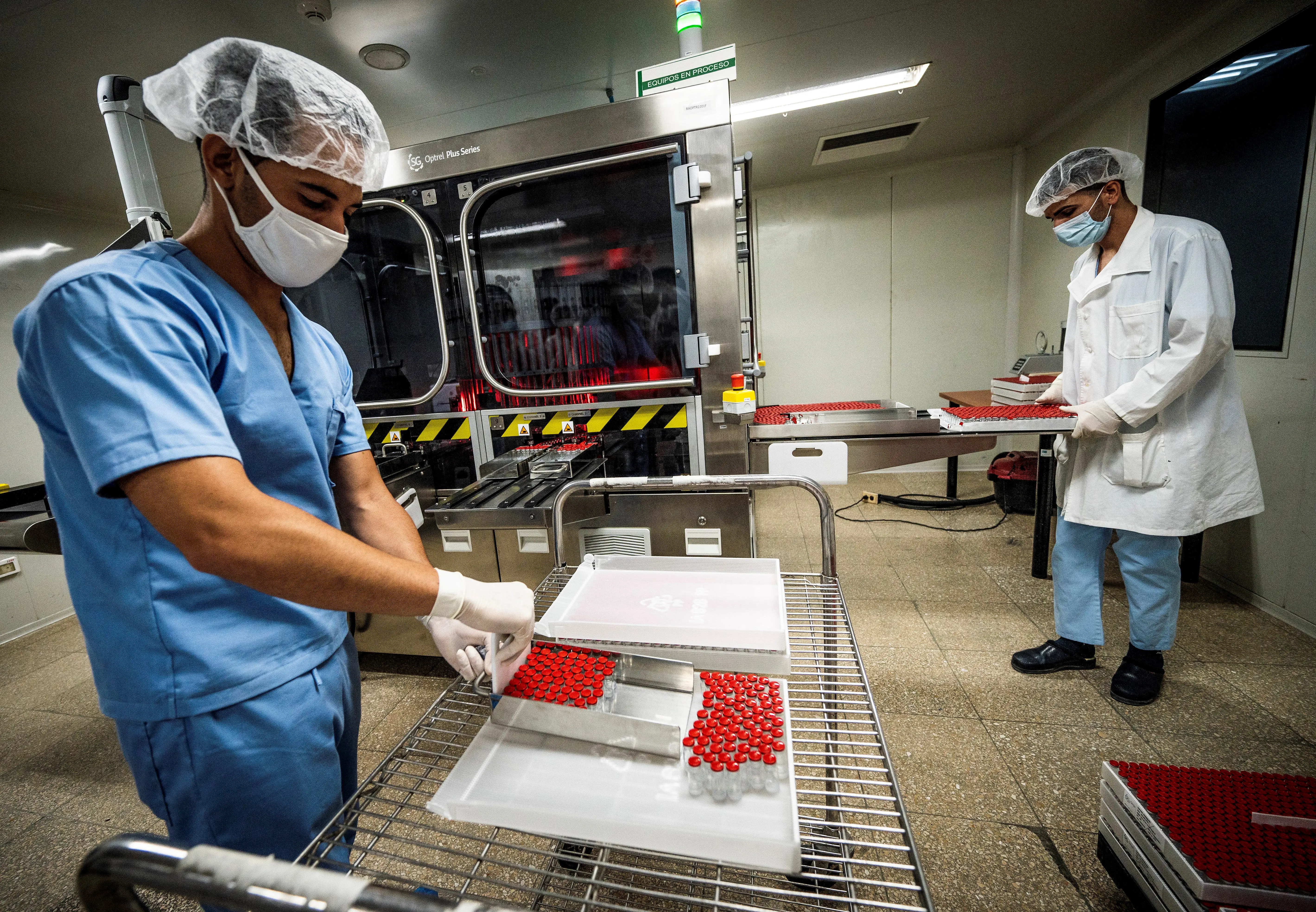Workers of the National Center for Biopreparations (BioCen), move vials of the Cuban-made VA-Mengoc-BC vaccine for meningococcal disease as they are prepared for packaging in Bejucal, Cuba, on July 15, 2022.