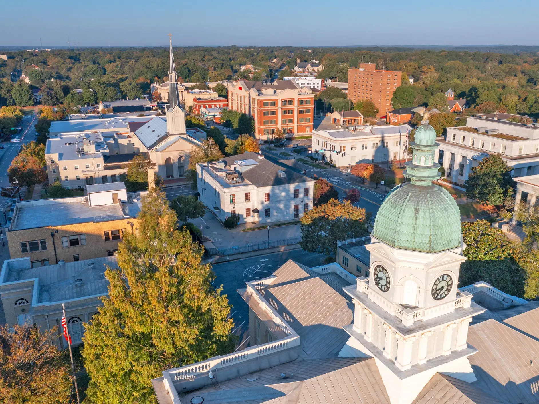 Aerial view of Athens, Georgia, USA, at dawn with the clock tower and surrounding civic buildings, church steeple, streets, and trees.