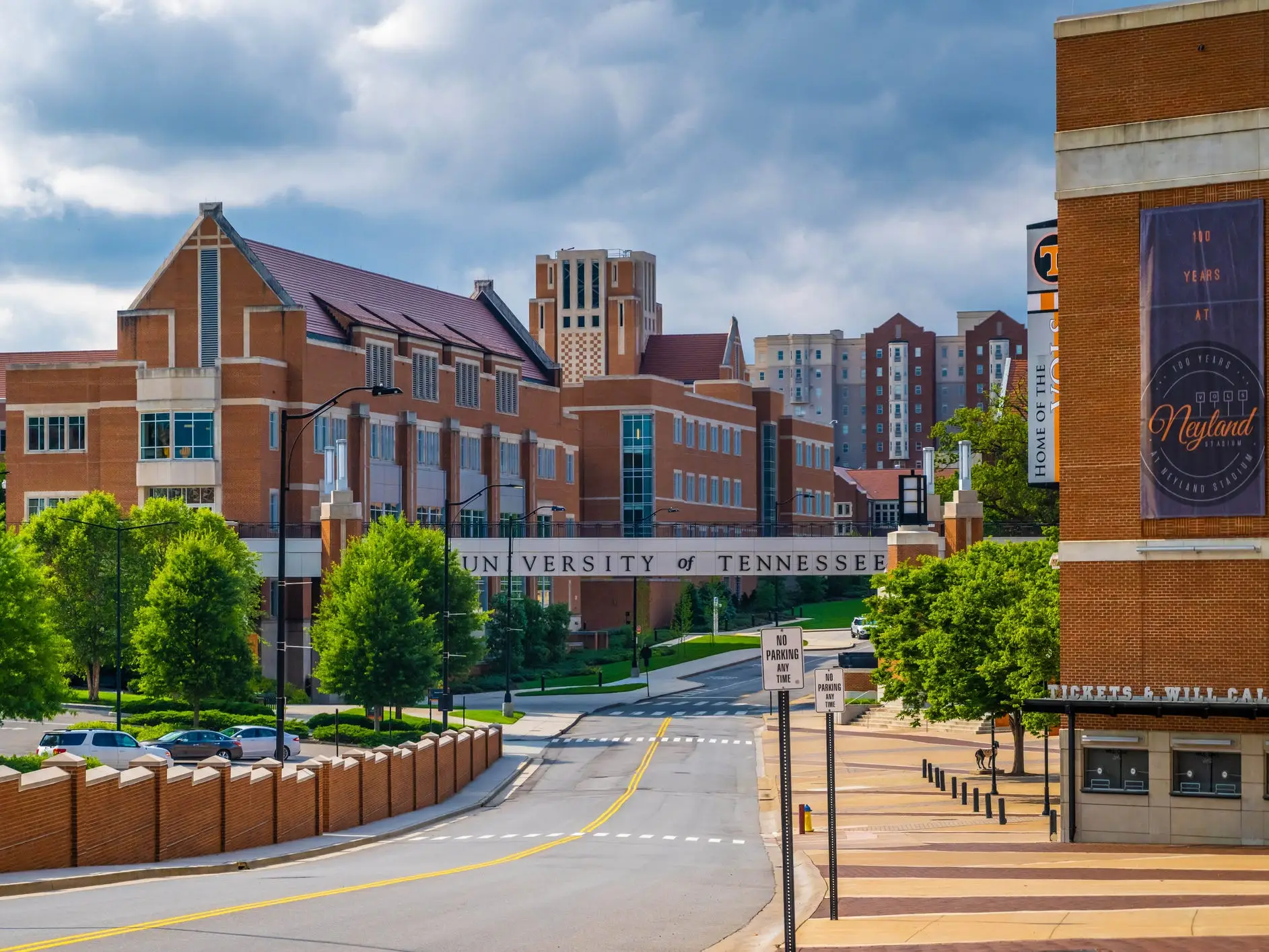 University of Tennessee campus buildings and Neyland Stadium area line a quiet road under cloudy skies.