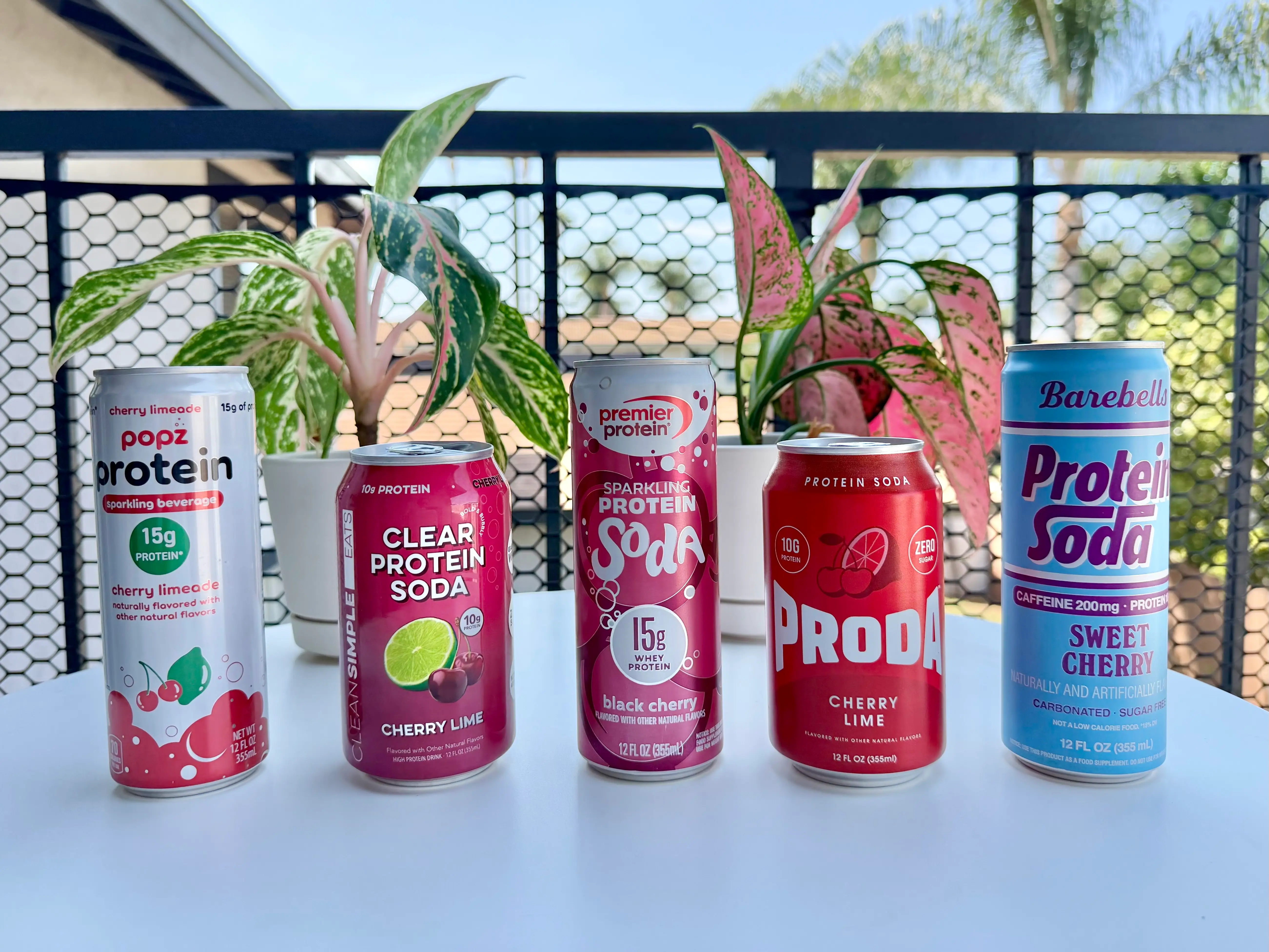 Line up of cherry protein sodas from Popz, Clean Simple Eats, Premier Protein, Proda, and Barebells