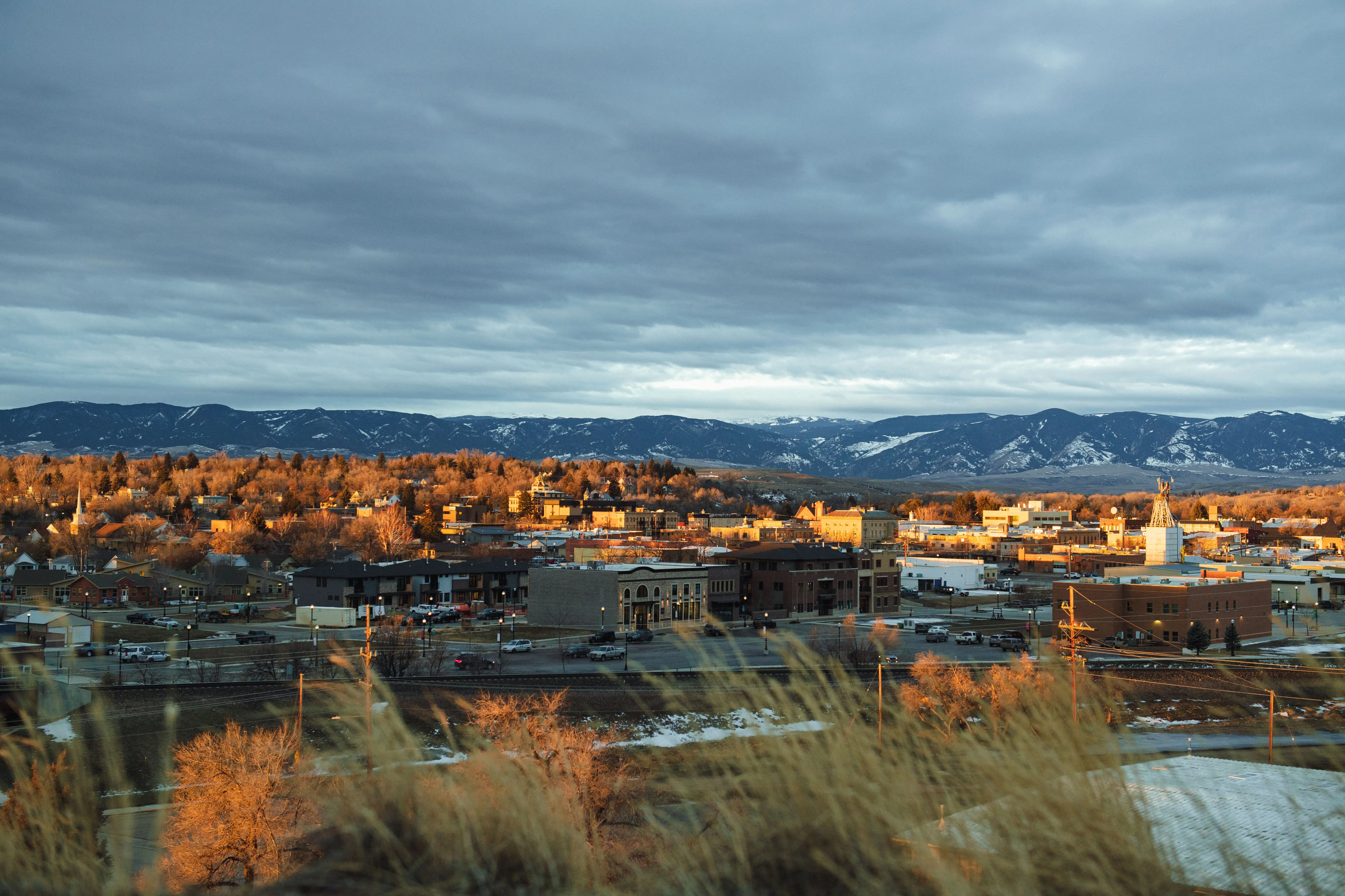 A small town sits below snow-capped mountains.