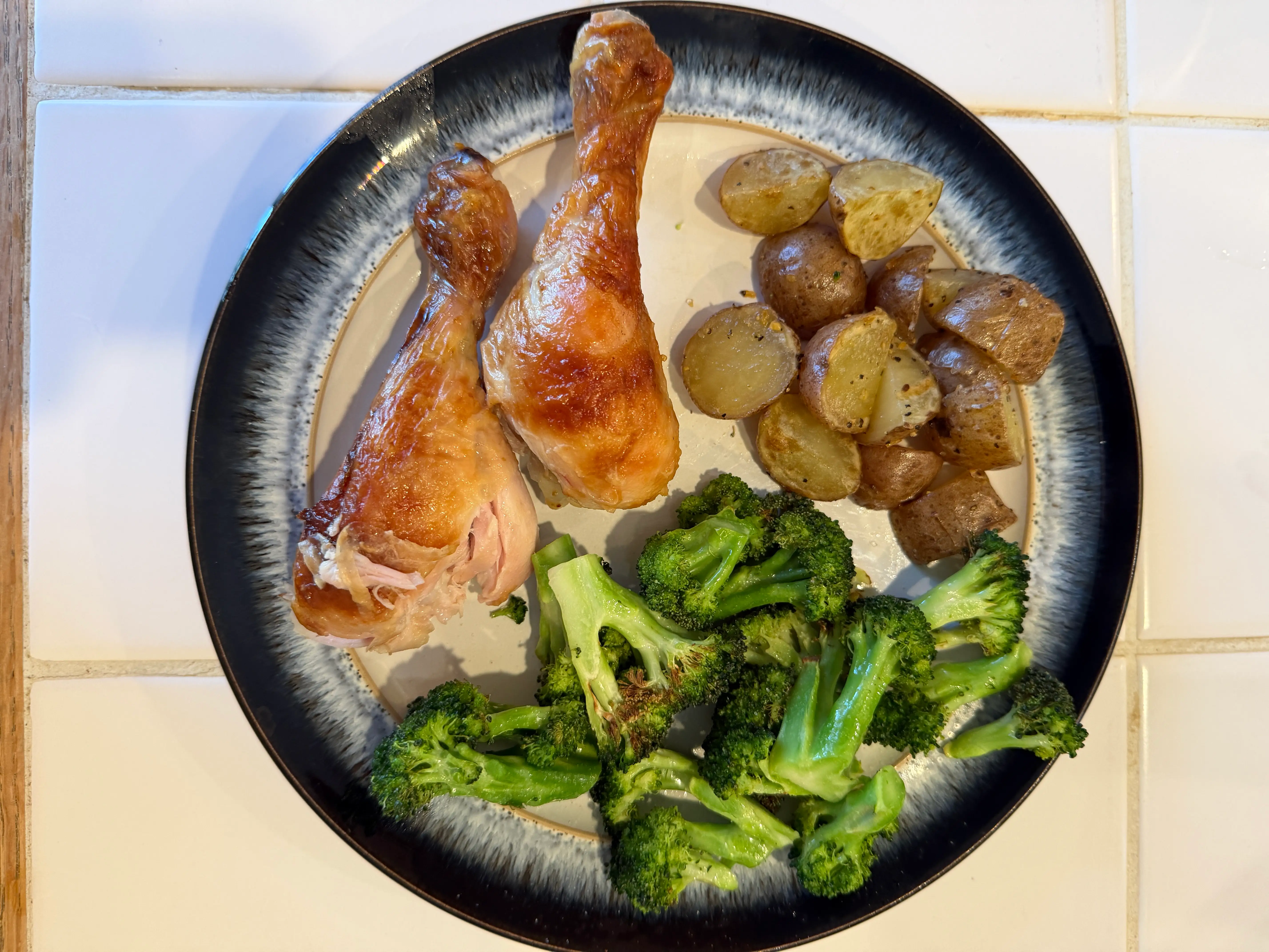 Chicken drumsticks with potatoes, broccoli, on plate