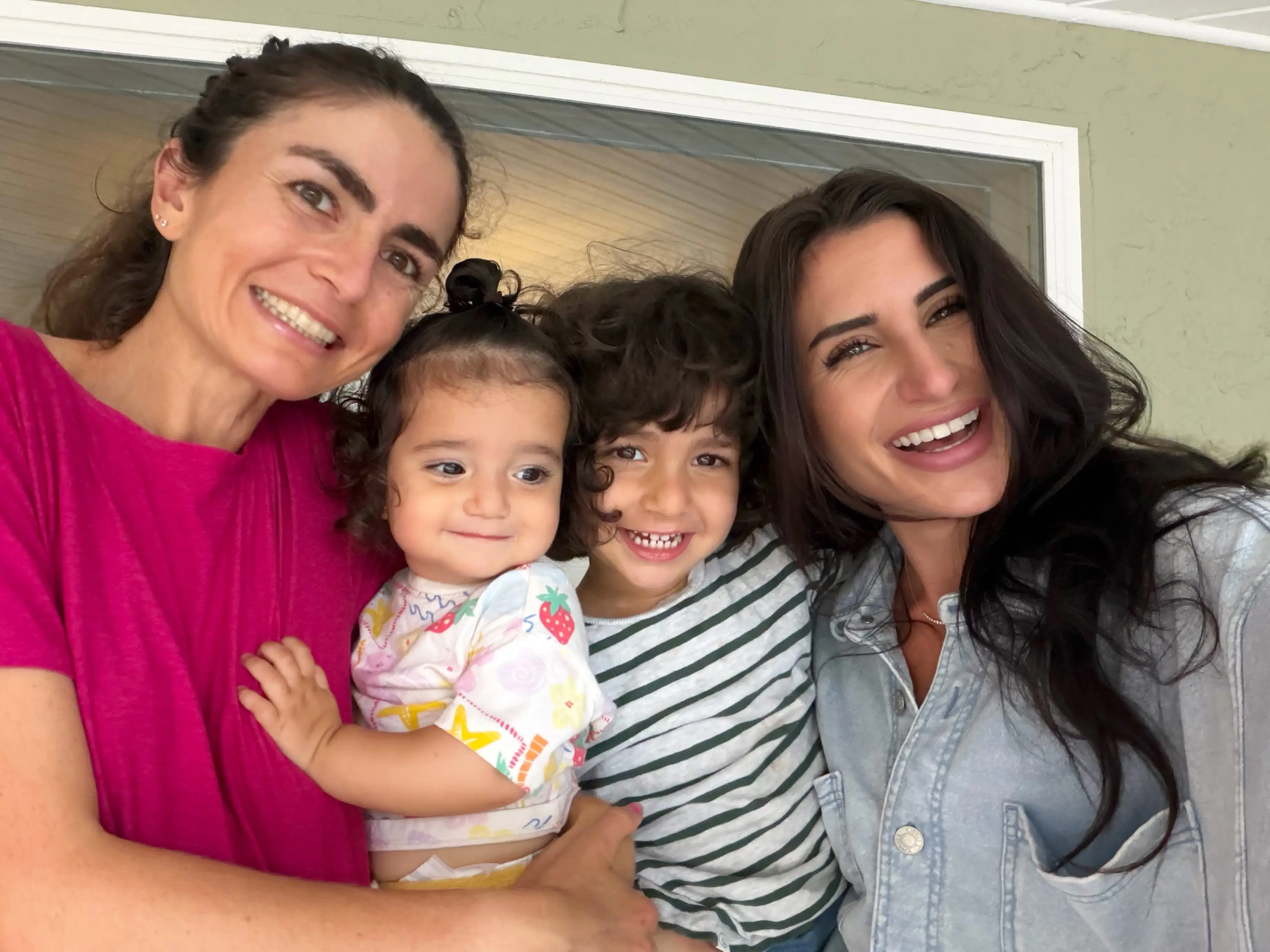 Two women smiling with two kids
