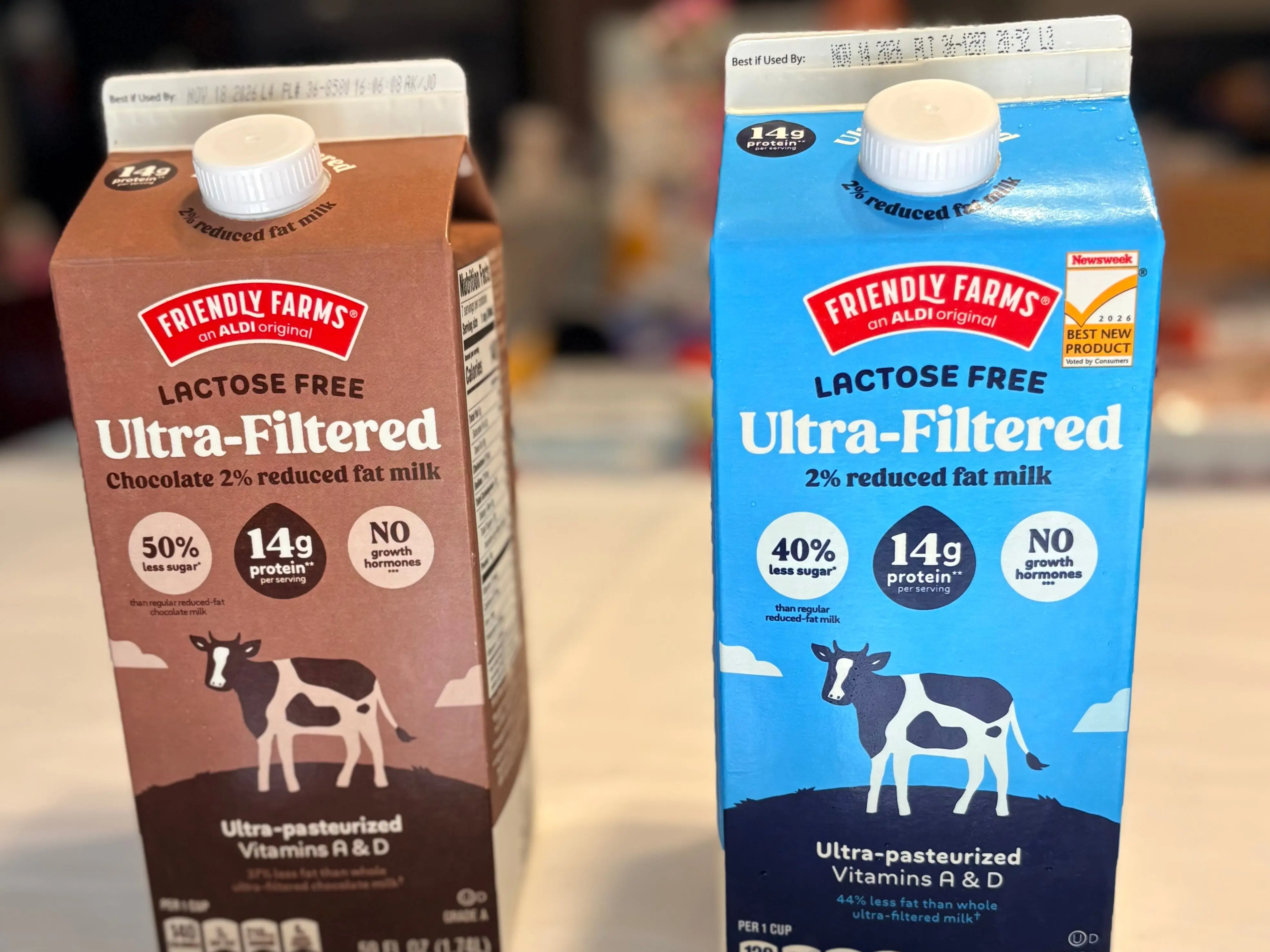 Two cartons of Friendly Farms lactose-free ultra-filtered milk stand on a table.