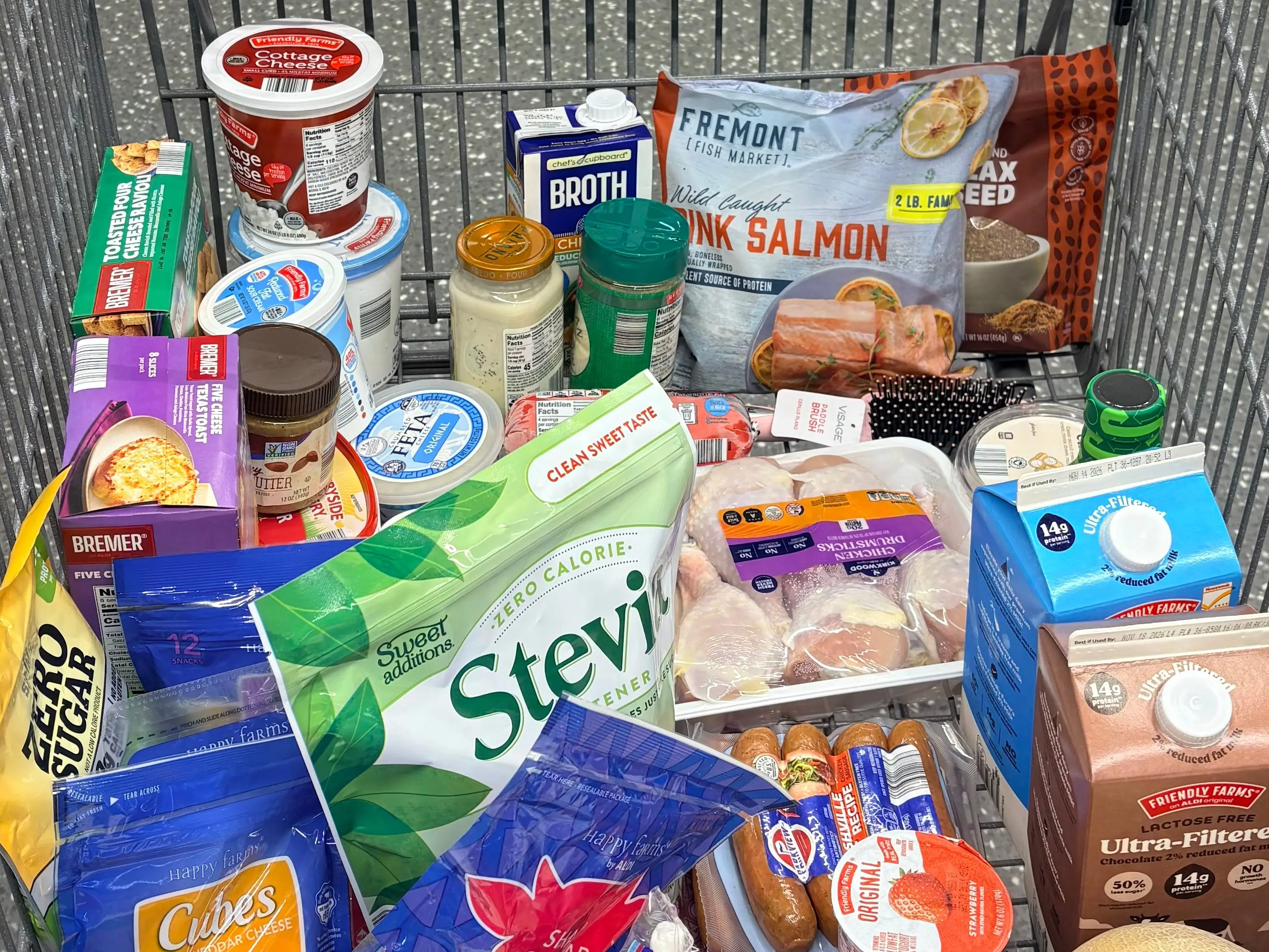 A grocery cart full of a variety of items and produce at Aldi.