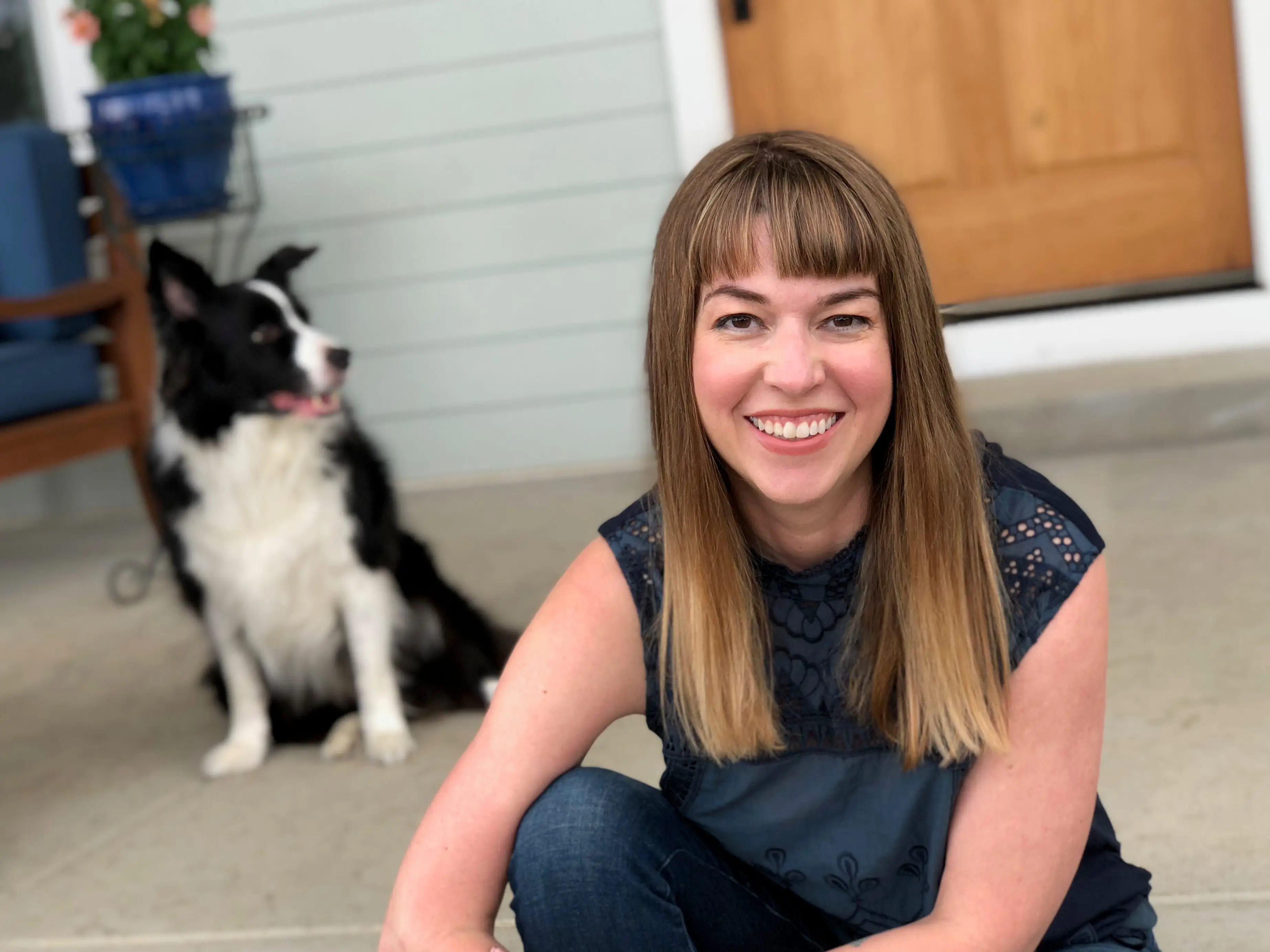the author sitting in front of a house with a dog on the steps