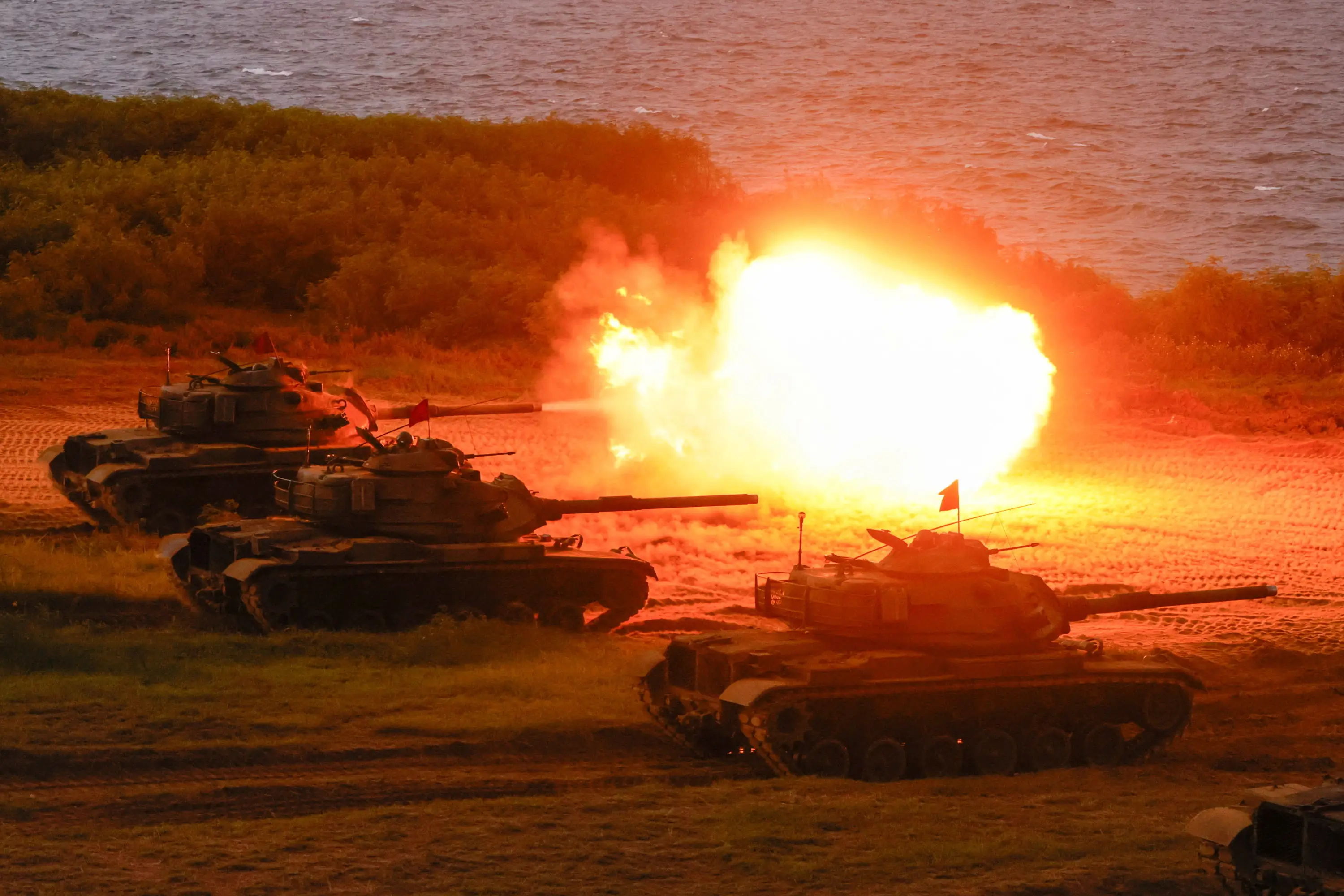 Three M60A3 tanks open fire.