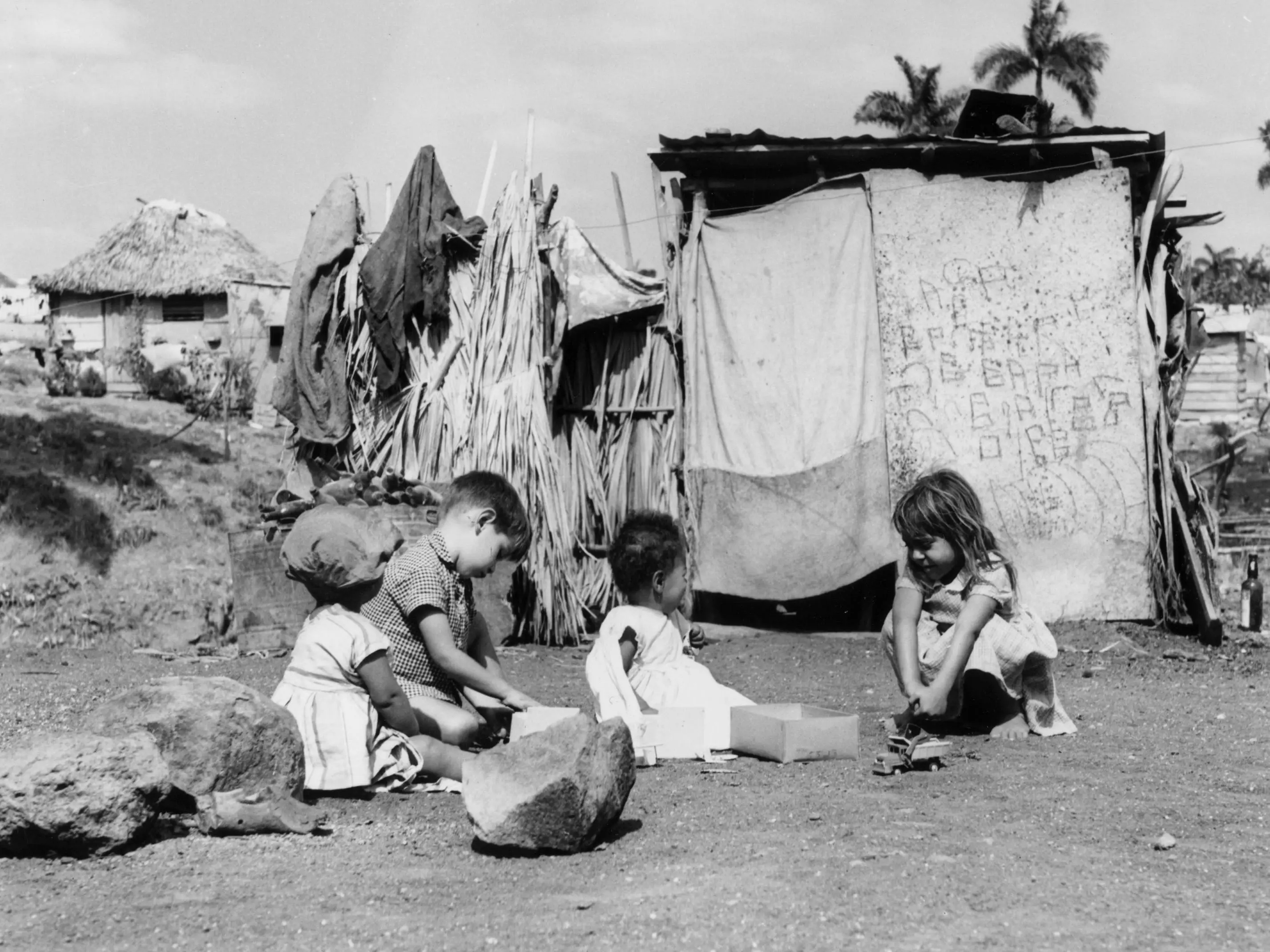 circa 1950: Children play outside their shanty homes in Oriente Province, Cuba.