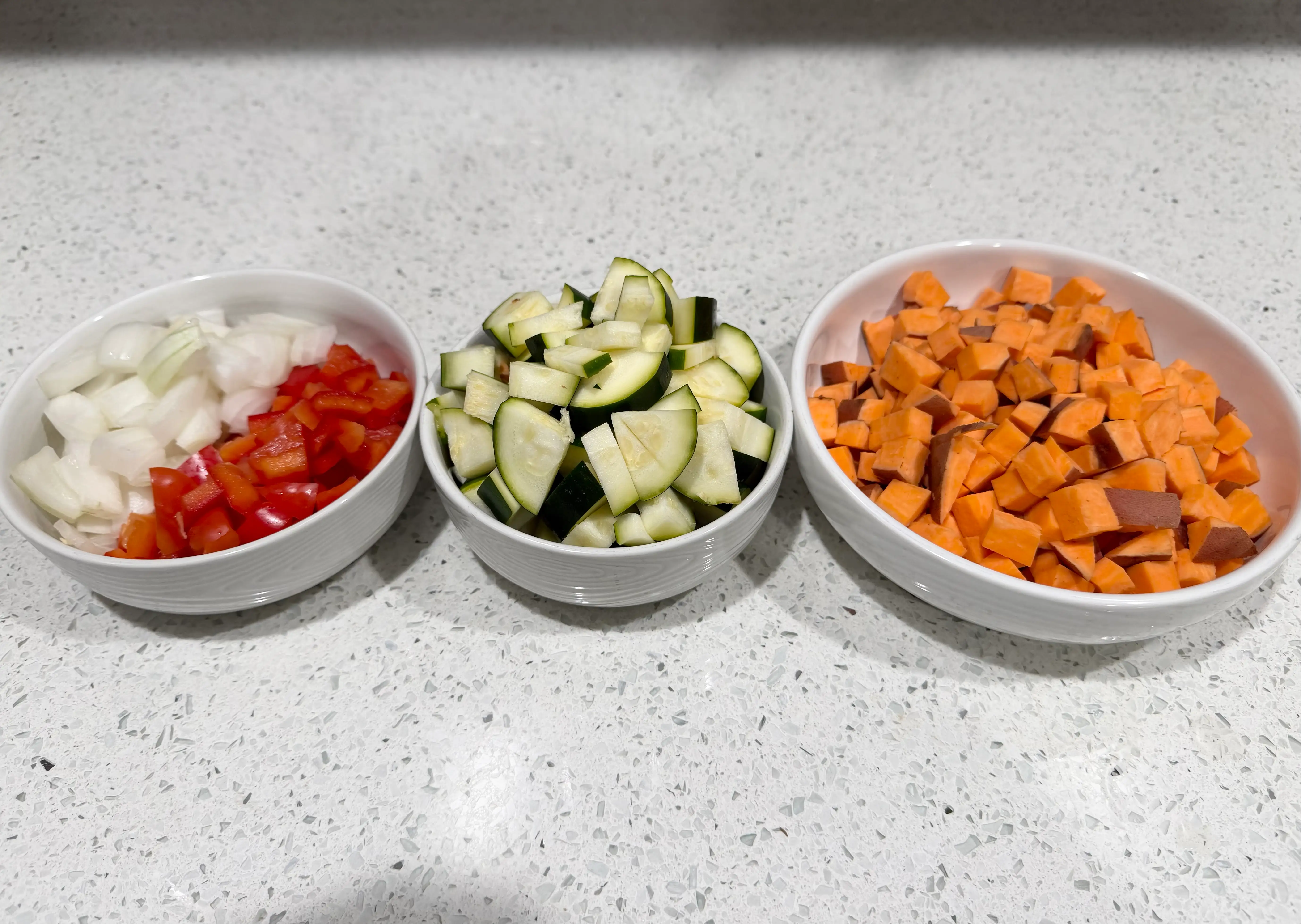 Bowls of choppde onion, pepper, zucchini, sweet potato