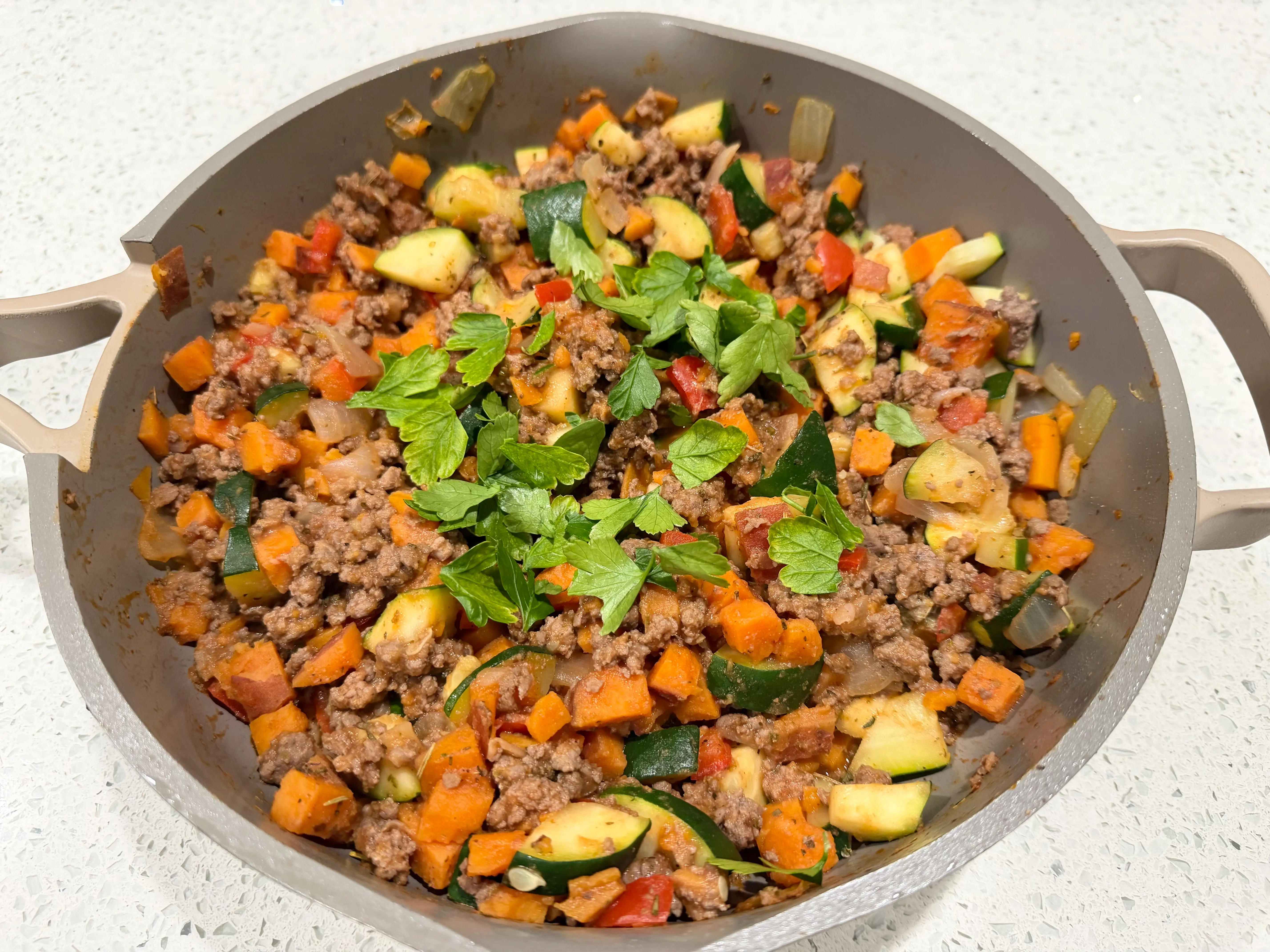 Pan with ground meat, veggies, topped with parsley